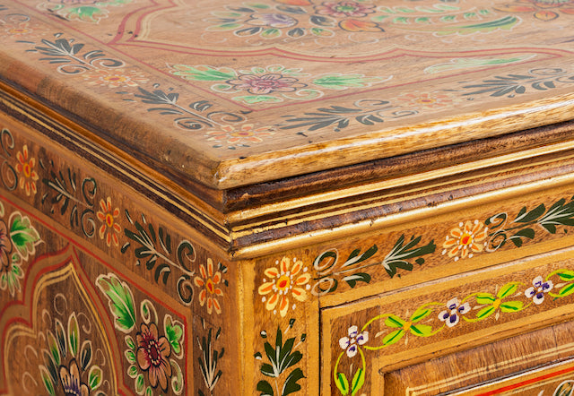 Close up image of a hand painted reclaimed wood cabinet with floral design in vintage style.