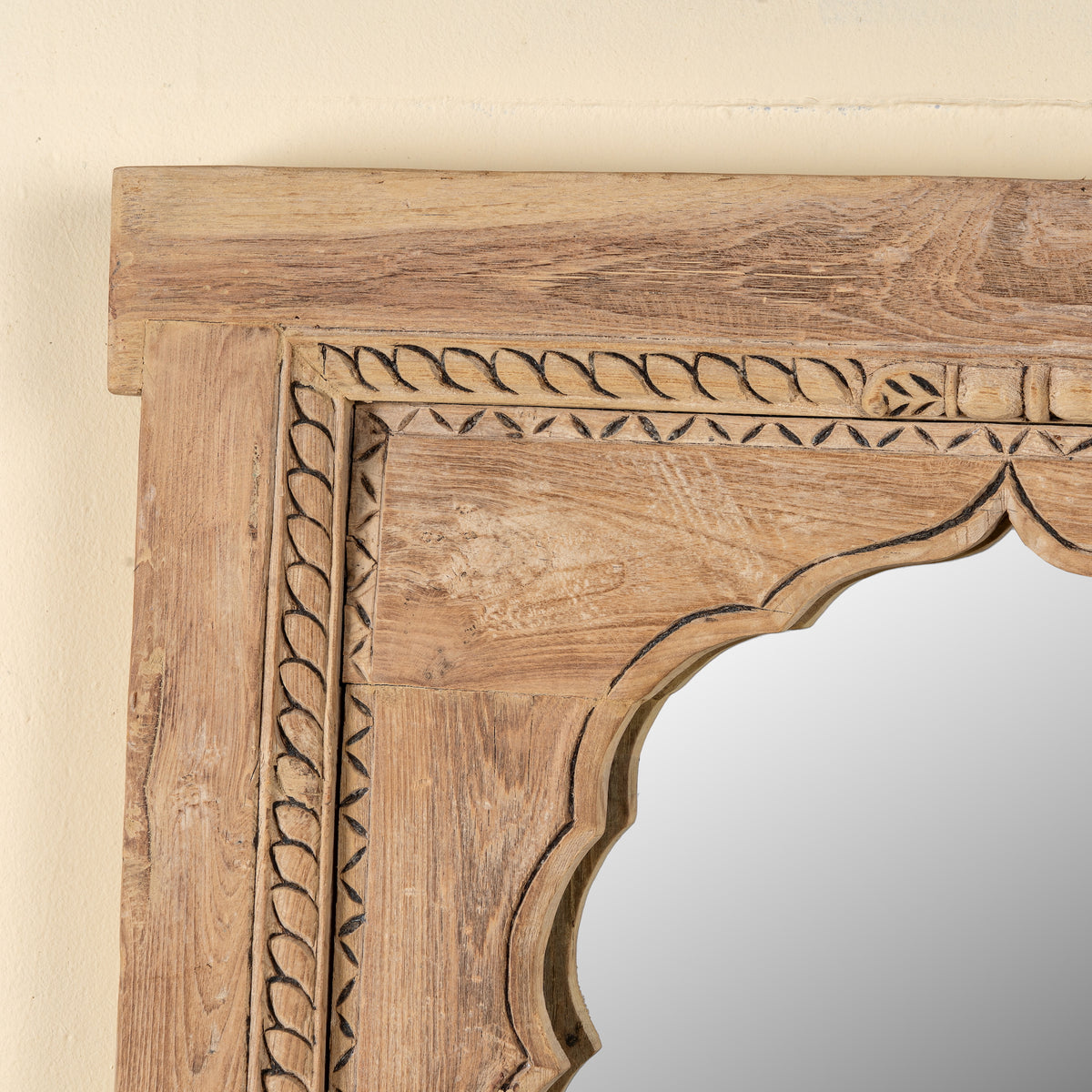 Close up image of a Aarshan reclaimed teak wood mirror made from an old Indian carved window frame with arched design, 84x120cm