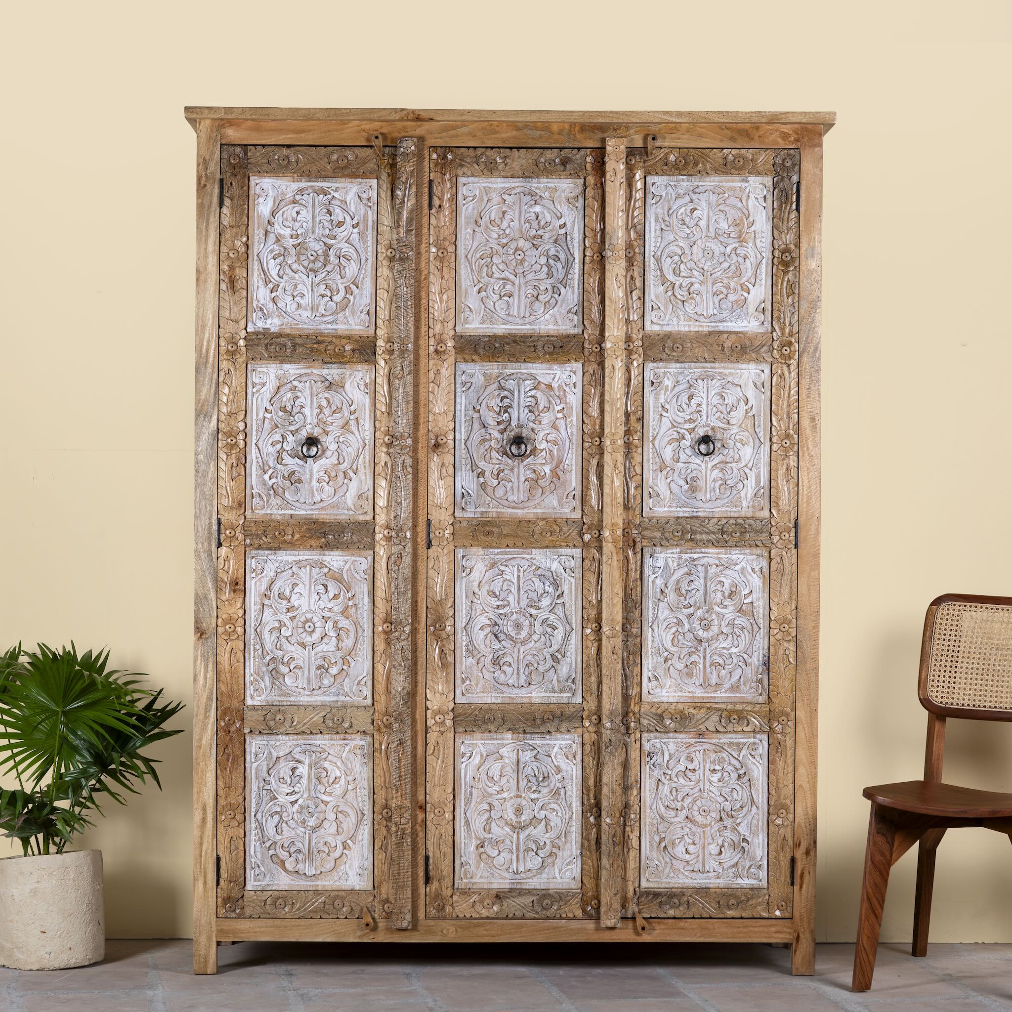 Image of a hand carved wardrobe with floral design made of mango wood in vintage style.
