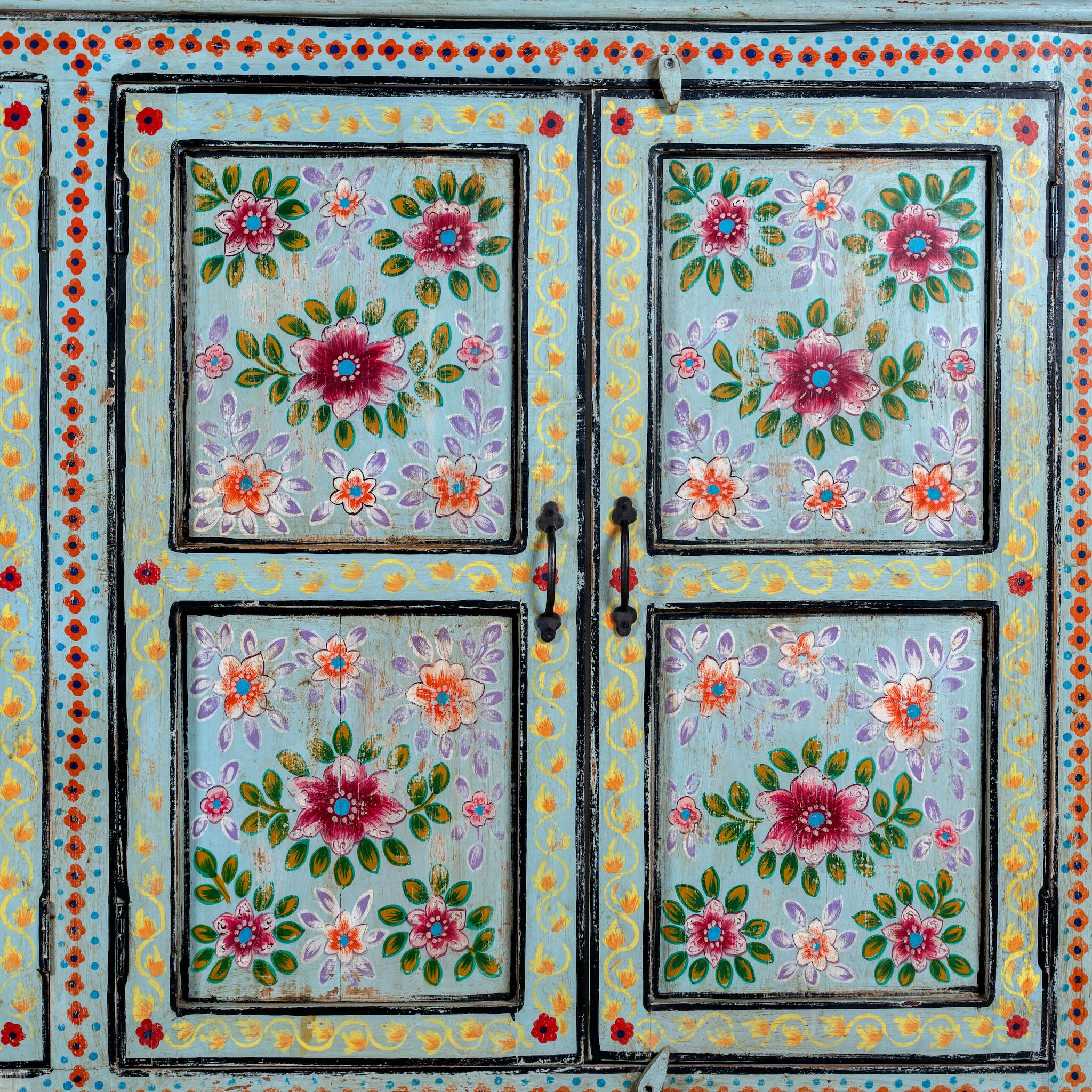 Close up image of a large hand painted, 2 parts, Mango wood display cabinet wit 8 doors and ample inside storage in vintage design.