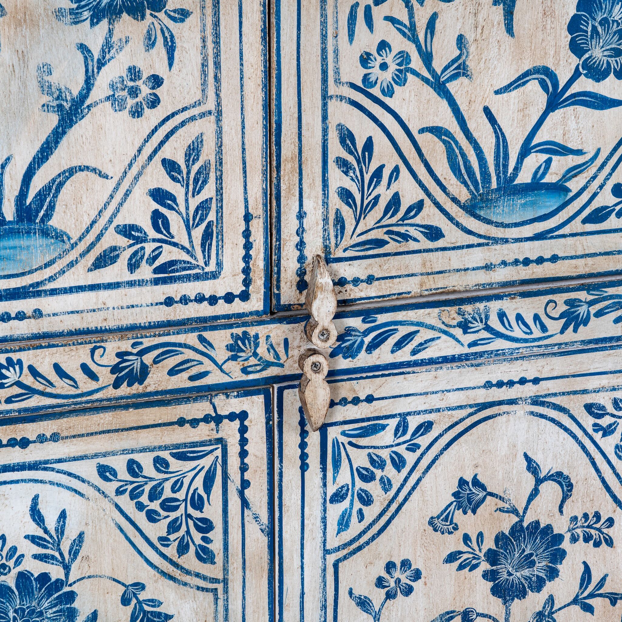 Close up image of a unique hand painted wardrobe made of reclaimed wood with floral design, 4 doors and ample storage.