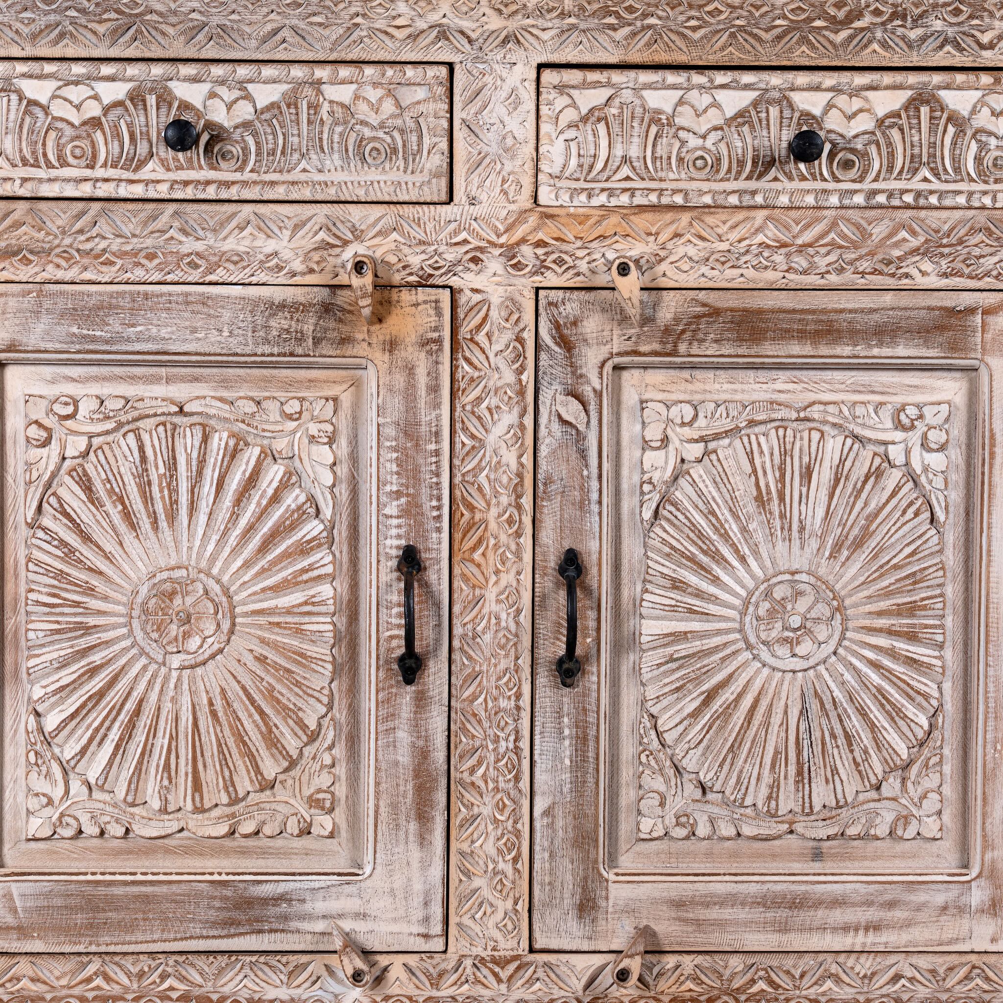 Close up image of a Abhiraj hand carved mango wood sideboard with distressed cream finish, three drawers and three doors, 150cm