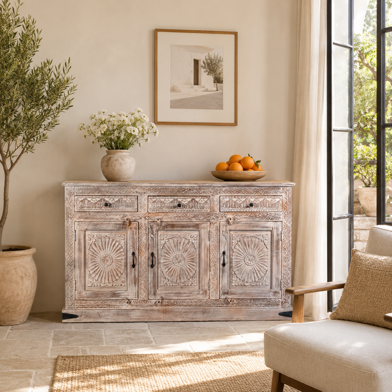 Lifestyle image of a Abhiraj hand carved mango wood sideboard with distressed cream finish, three drawers and three doors, 150cm