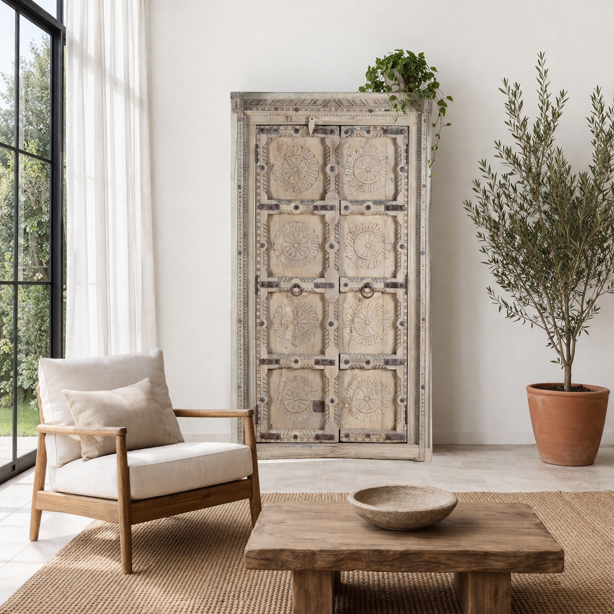 Lifestyle image of a reclaimed teak wood cabinet Ahara with Mediterranean design, featuring hand-carved antique Indian doors and metal accents. A unique piece of old door furniture ideal for stylish, character-rich living room storage.