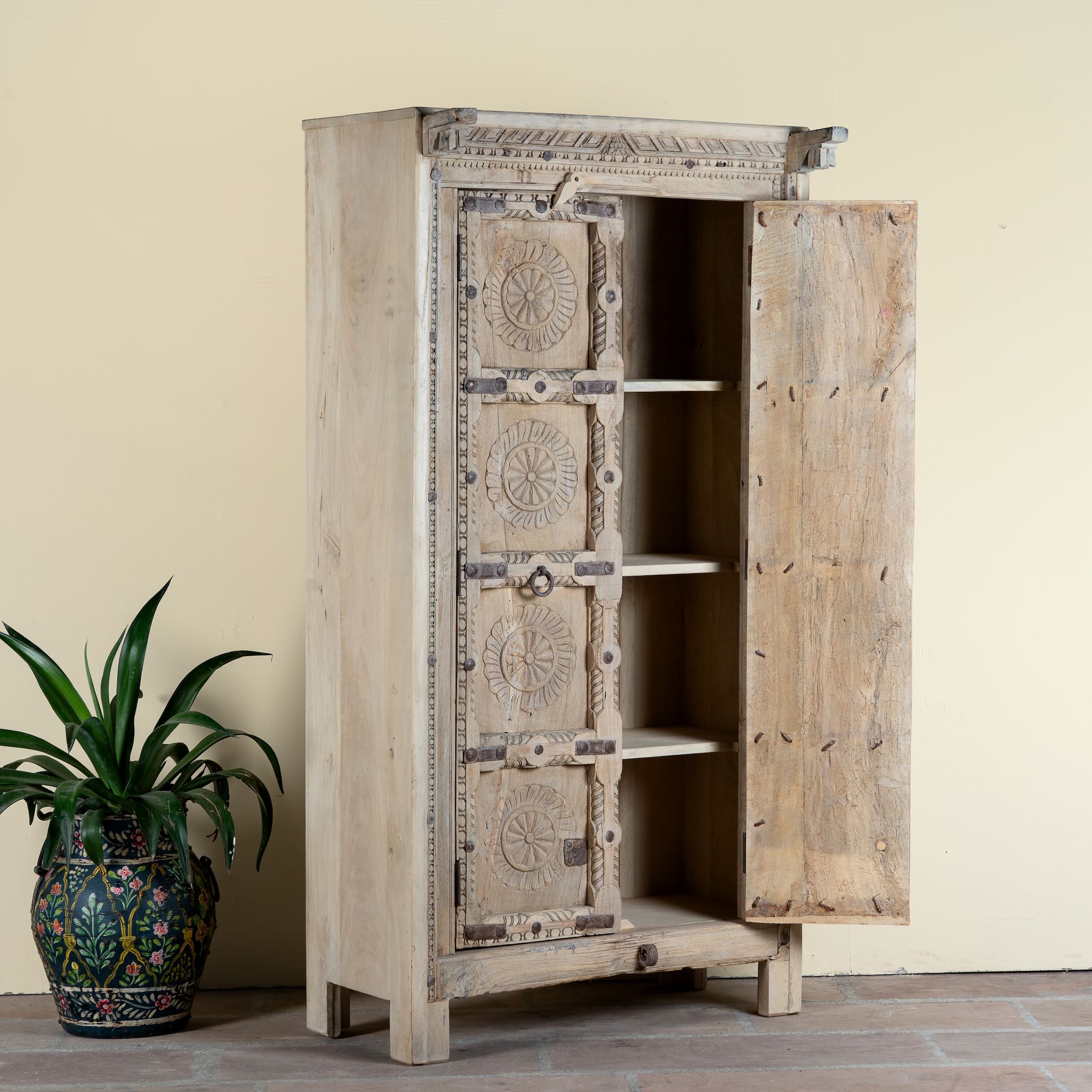 Side angle image with open door of a reclaimed teak wood cabinet Ahara with Mediterranean design, featuring hand-carved antique Indian doors and metal accents. A unique piece of old door furniture ideal for stylish, character-rich living room storage.