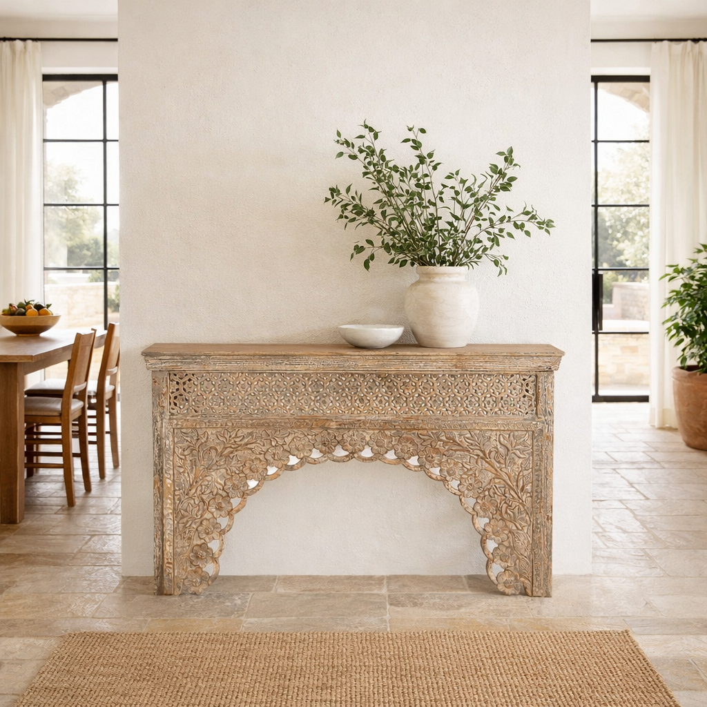 Lifestyle image of a vintage console table in mango wood with hand-carved floral and geometric patterns and arched detailing; carved console table, 150 × 90 × 40 cm.