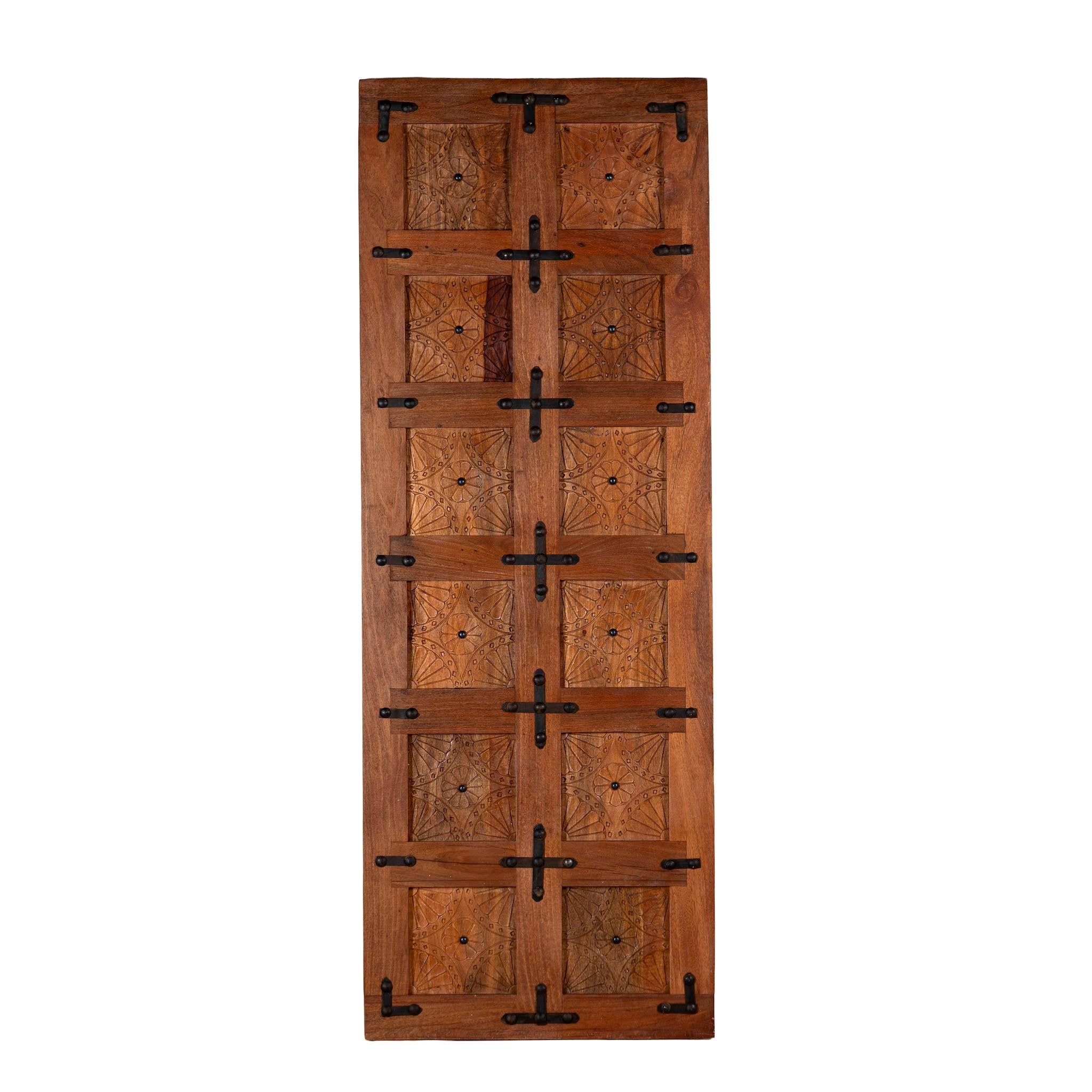 White background image of a sliding door panel made from reclaimed wood with detailed hand carvings and traditional iron fittings, combining rustic elegance with functional design.
