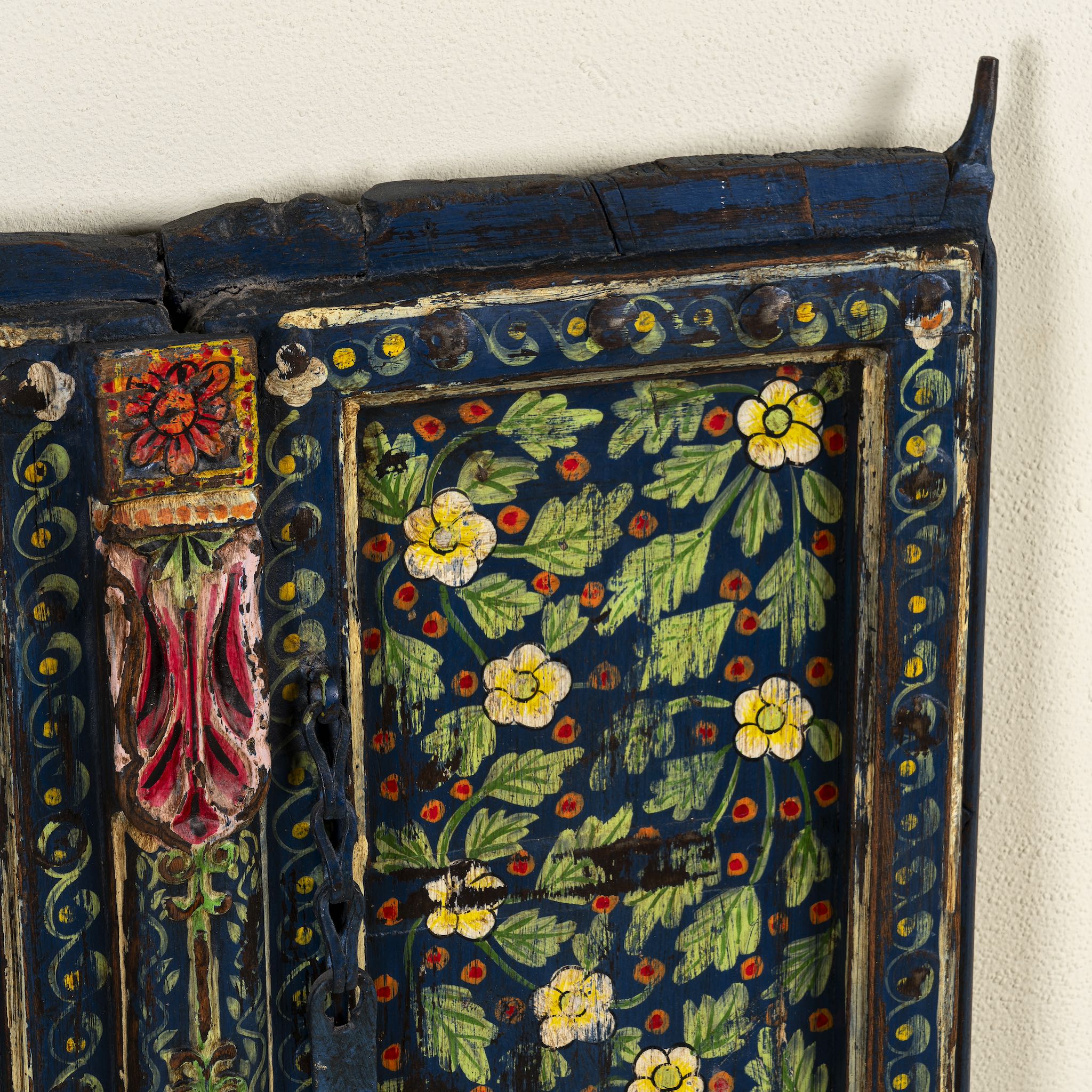 Close up image of a vintage hand-painted wall panel made from reclaimed Indian teak wood with floral blue motifs – Amol model by Om Home & Garden