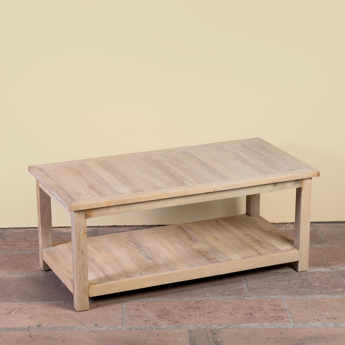 Side angle image of a Anil bleached reclaimed wood coffee table with rectangular top and full-width lower storage shelf, 120x60x50cm
