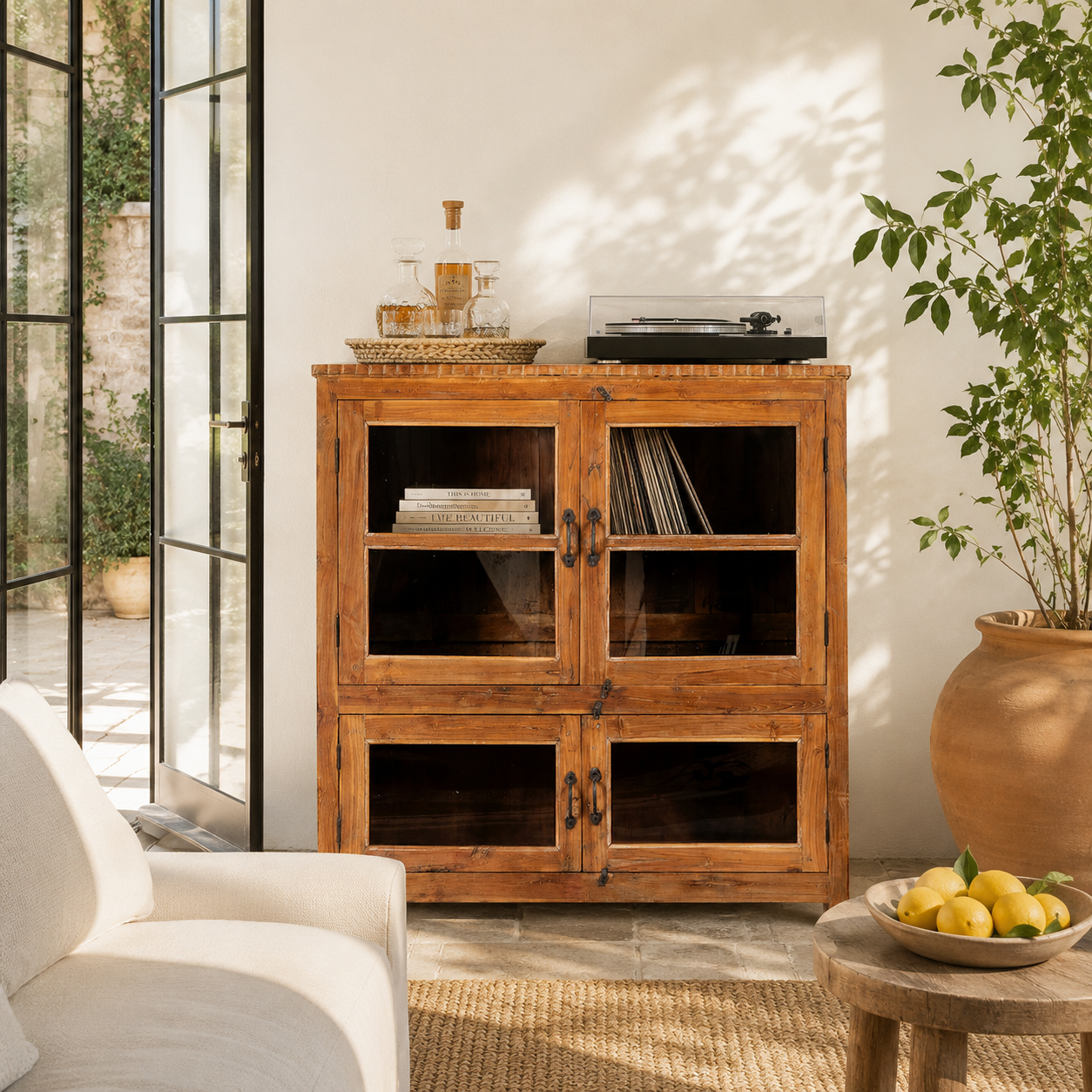 Lifestyle image of a reclaimed teak wood display cabinet with four glass-panelled doors – wooden showcase cabinet crafted as sustainable furniture with timeless appeal.