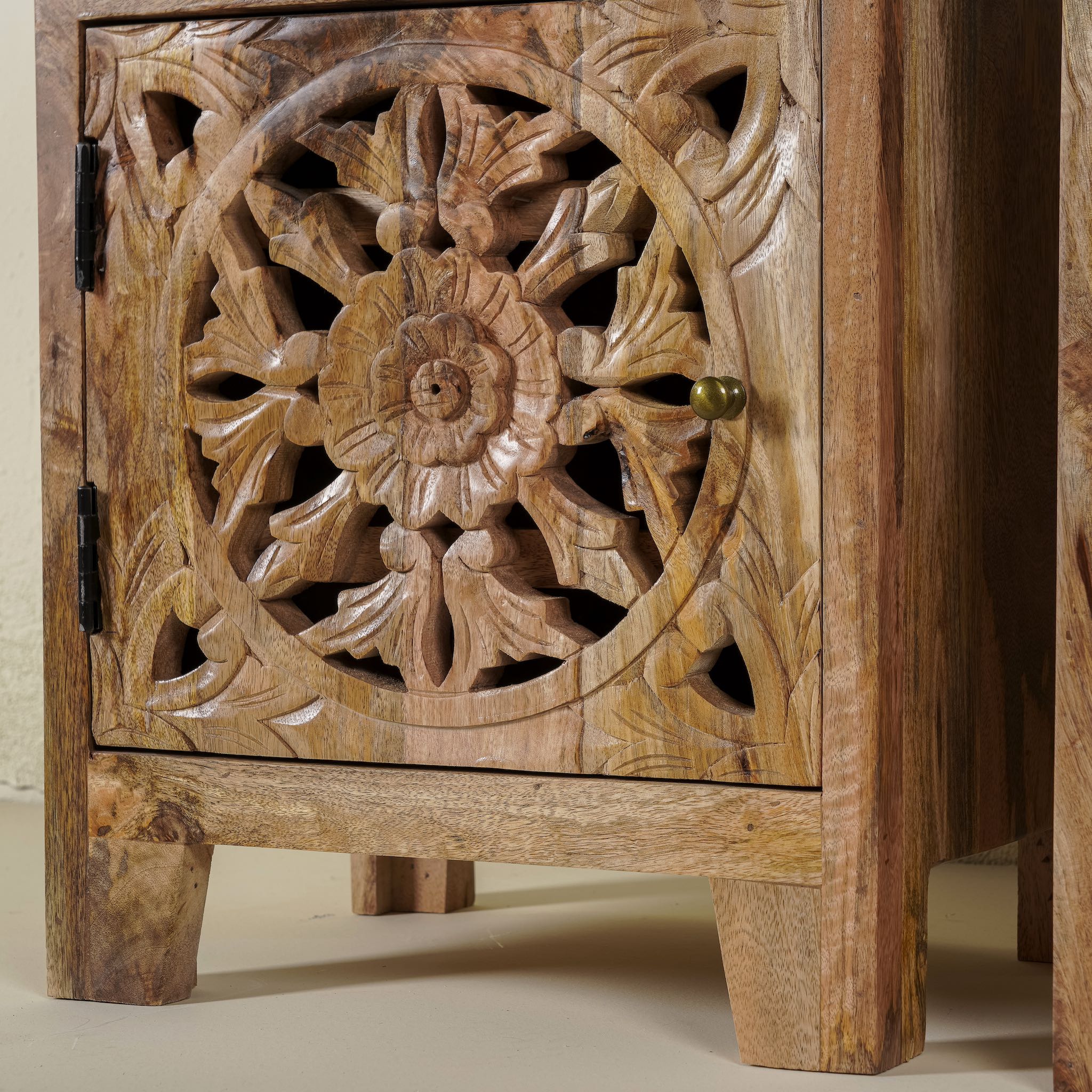 Close up picture of a pair of mango wood bedside tables with floral and geometric carvings; natural finish mango wood furniture ideal for bedroom furniture, 45 × 65 × 35 cm.