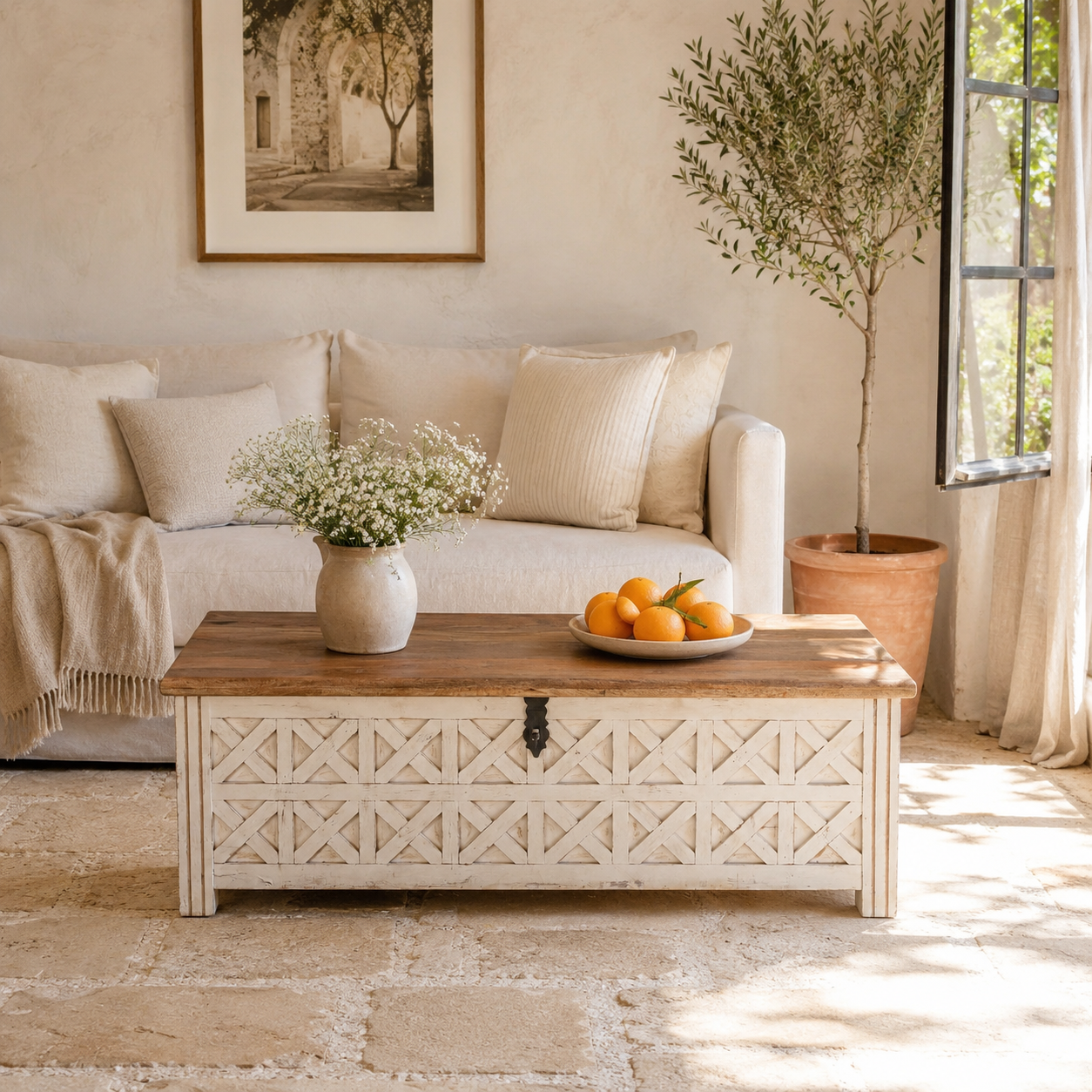 Lifestyle image of a hand-carved mango wood vintage chest front view – styled in Mediterranean living room with books, candles, natural textures, and soft daylight.