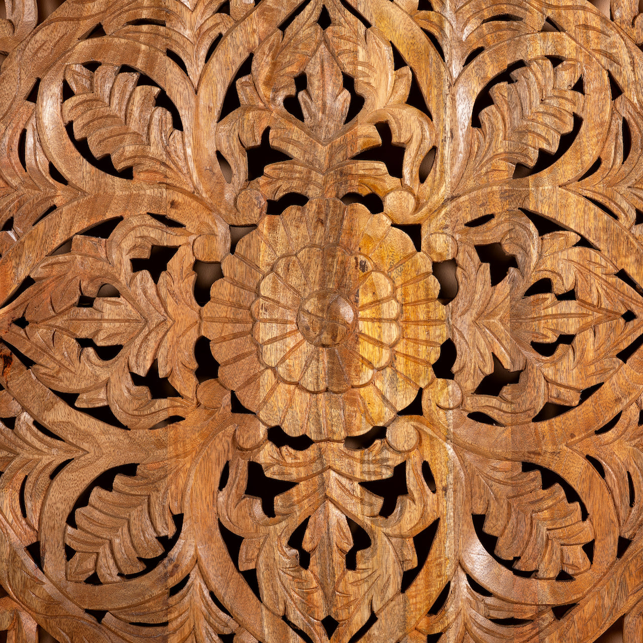 Close up image of a Hand-carved mango wood wall panel with intricate floral design and natural finish – Aruna model by Om Home & Garden