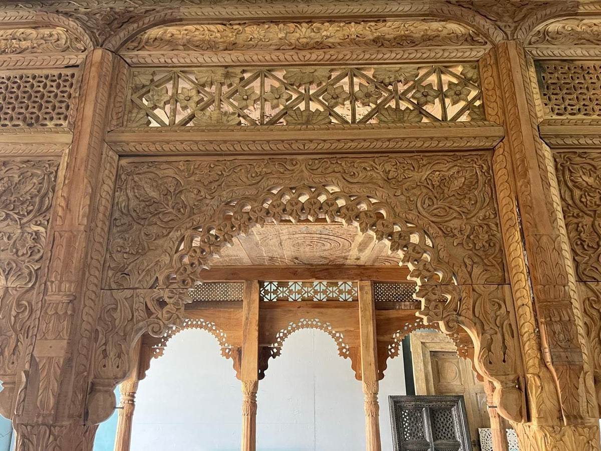Close up image of a Bageecha hand carved reclaimed wood garden house with flat roof, ornamental arches and carved pillars 375cm