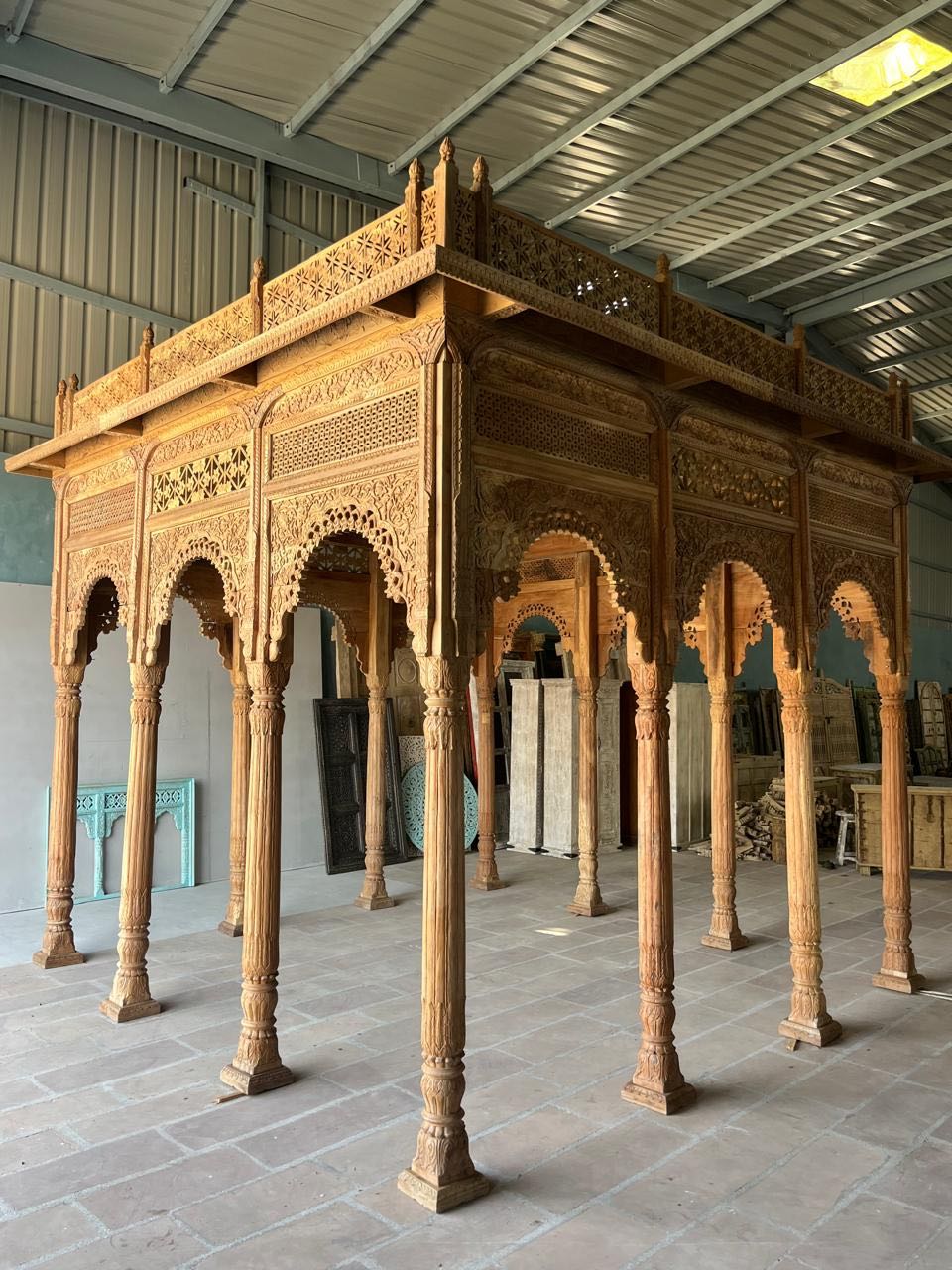 Side angle image of a Bageecha hand carved reclaimed wood garden house with flat roof, ornamental arches and carved pillars 375cm