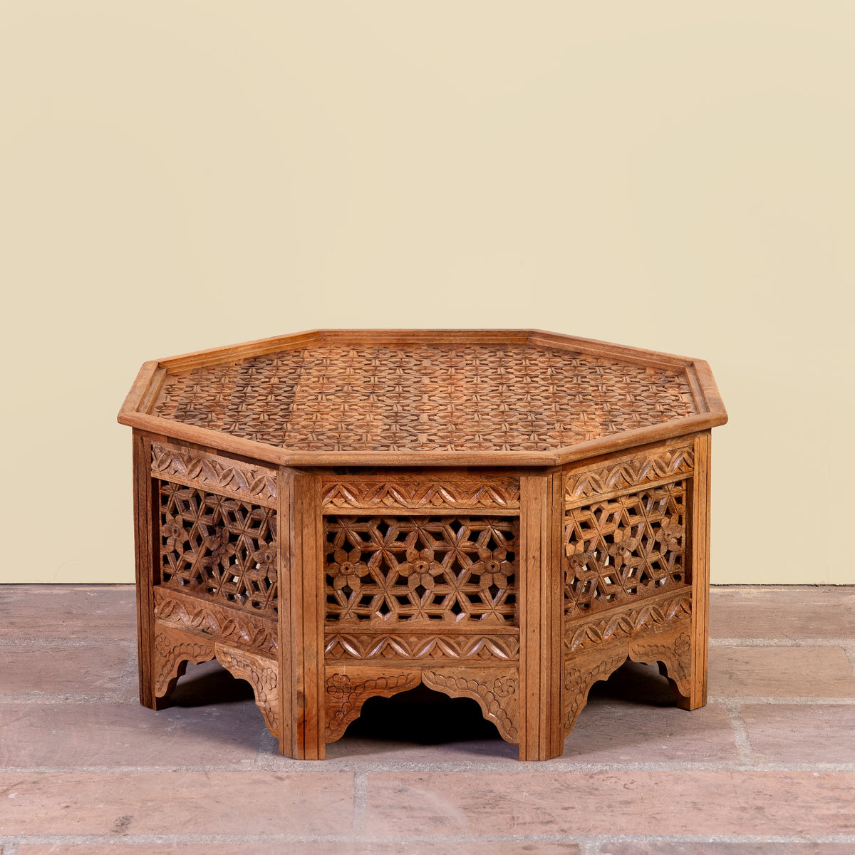 Image of a Barkot octagonal mango wood coffee table with intricate floral and geometric carvings; durable hand-carved coffee table, 90 × 90 × 46 cm.