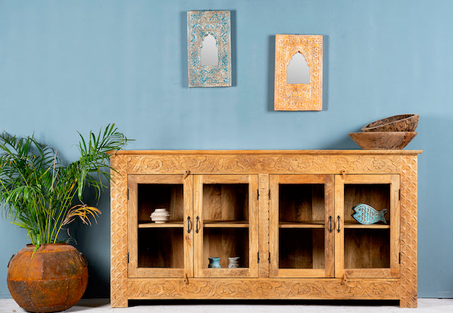 Hand-carved wooden showcase Barot made from natural mango wood, featuring detailed floral carvings across its front. A sustainable piece of Indian furniture online ideal for living room furniture with a Mediterranean and boho-style design.