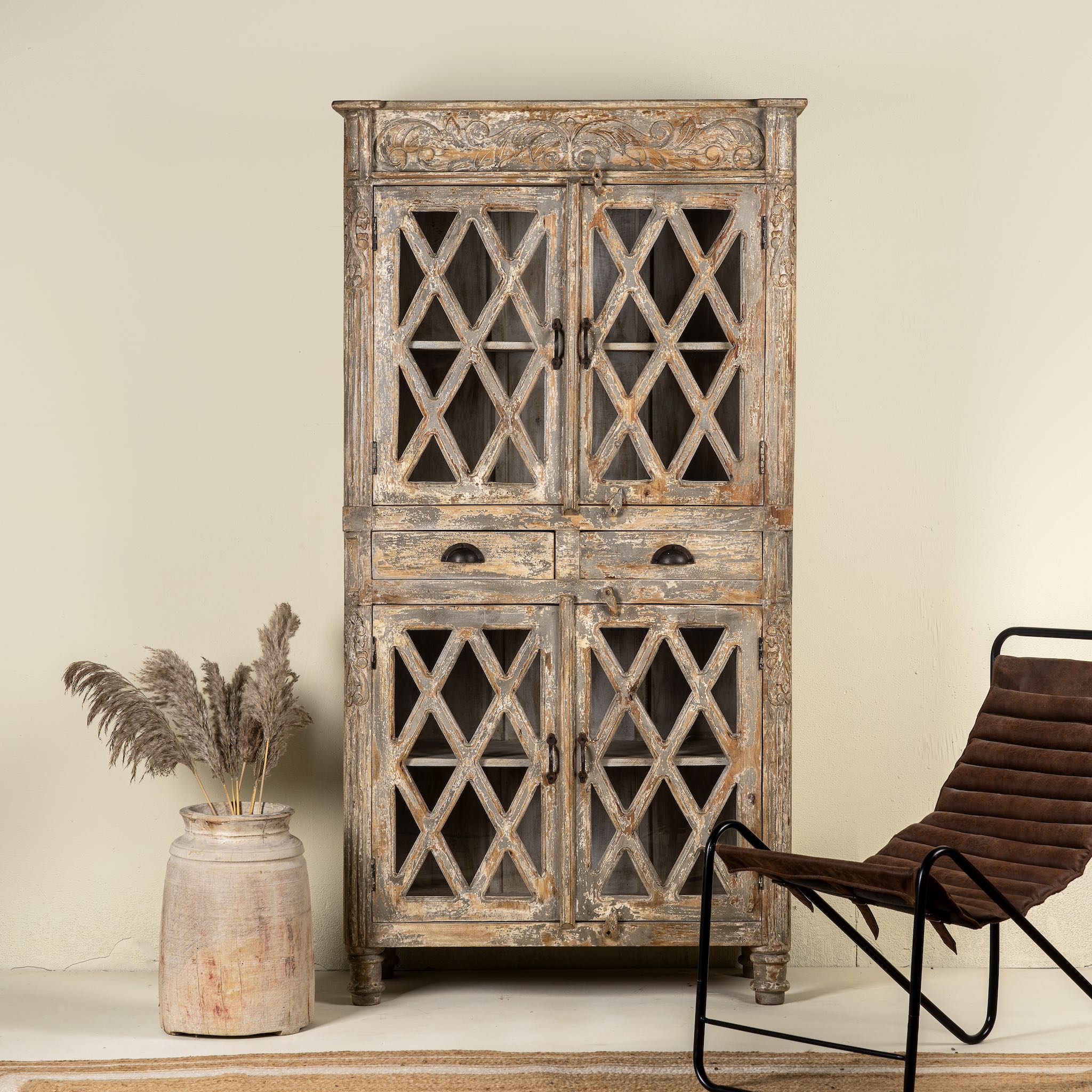 Vintage display cabinet made from solid mango wood with glass doors and shelving – handcrafted Ibiza-style showcase with carved details.