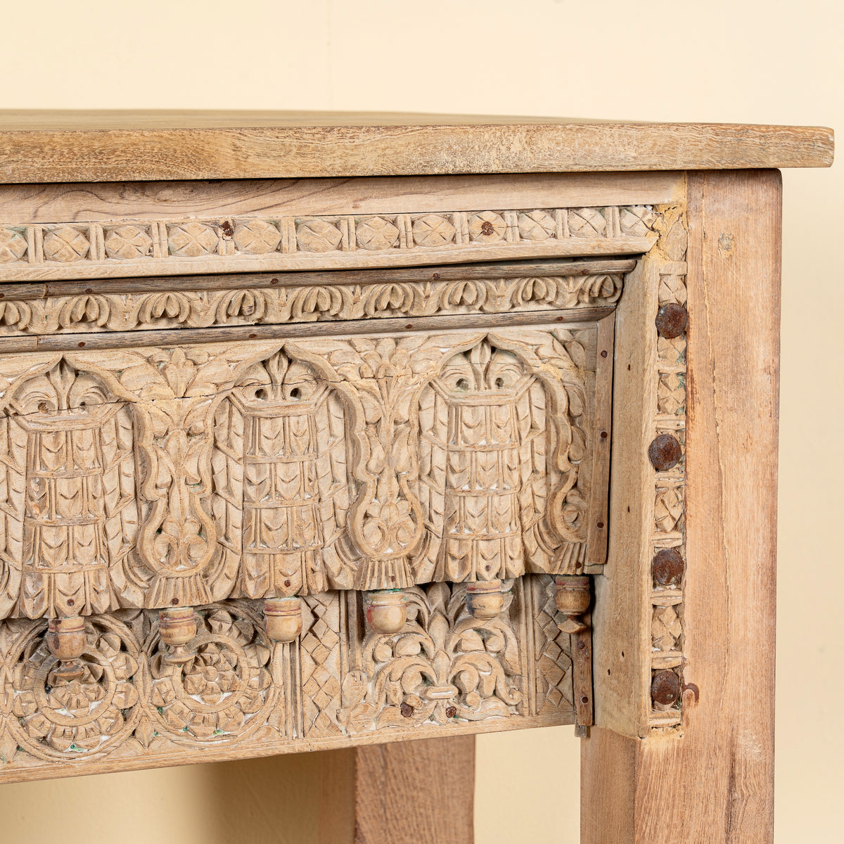 Close up image of a Bhaskar reclaimed teak wood console table with carved old Indian house elements and lower storage shelf 118cm