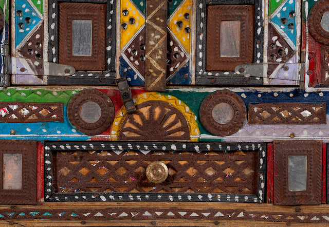 Close up image of a restored antique Indian Damchia chest crafted from teak wood with original paint, metal fittings, and mirror inlays—an authentic piece of unique Indian furniture for traditional or bohemian interiors.