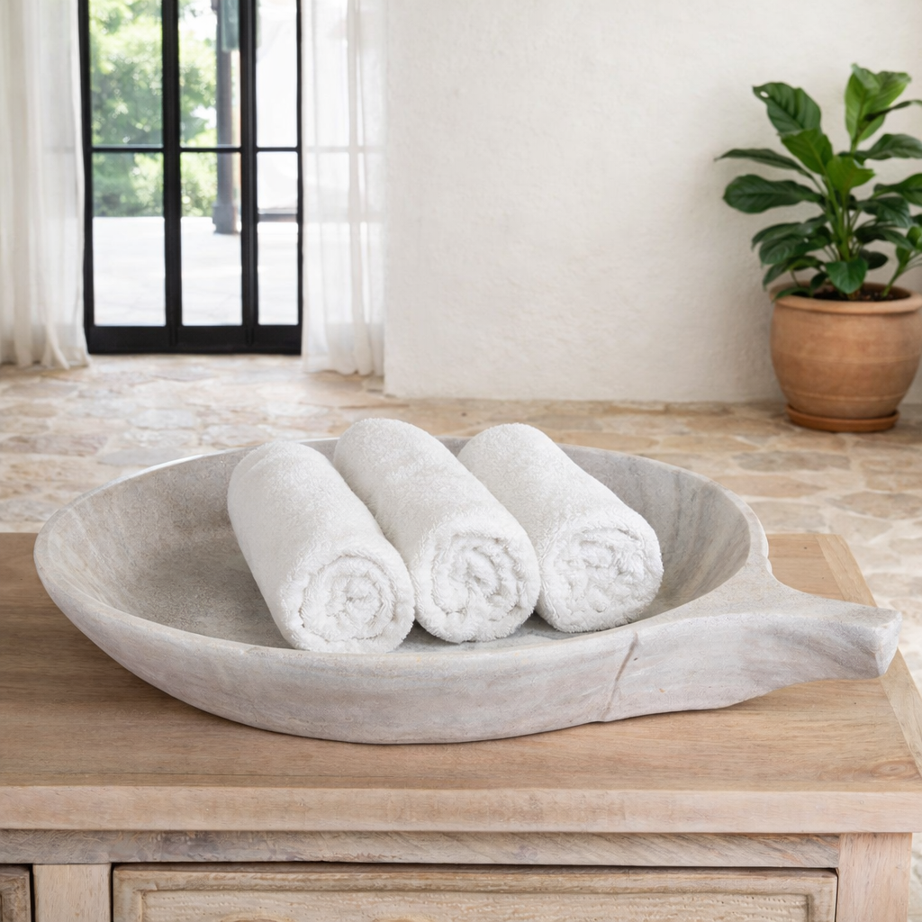 Lifestyle image of a hand-carved white marble plate Brij with shallow round form and side handle. A vintage home accessory and unique Indian decoration, ideal as a fruit plate or for bathroom storage in vintage home decor settings.