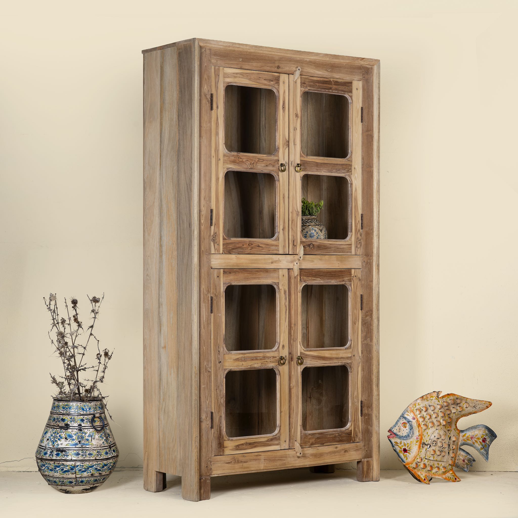 Side angle view of Chander tall vitrine with reclaimed teak door panels, a refined piece of teak wood furniture for living room furniture collections.