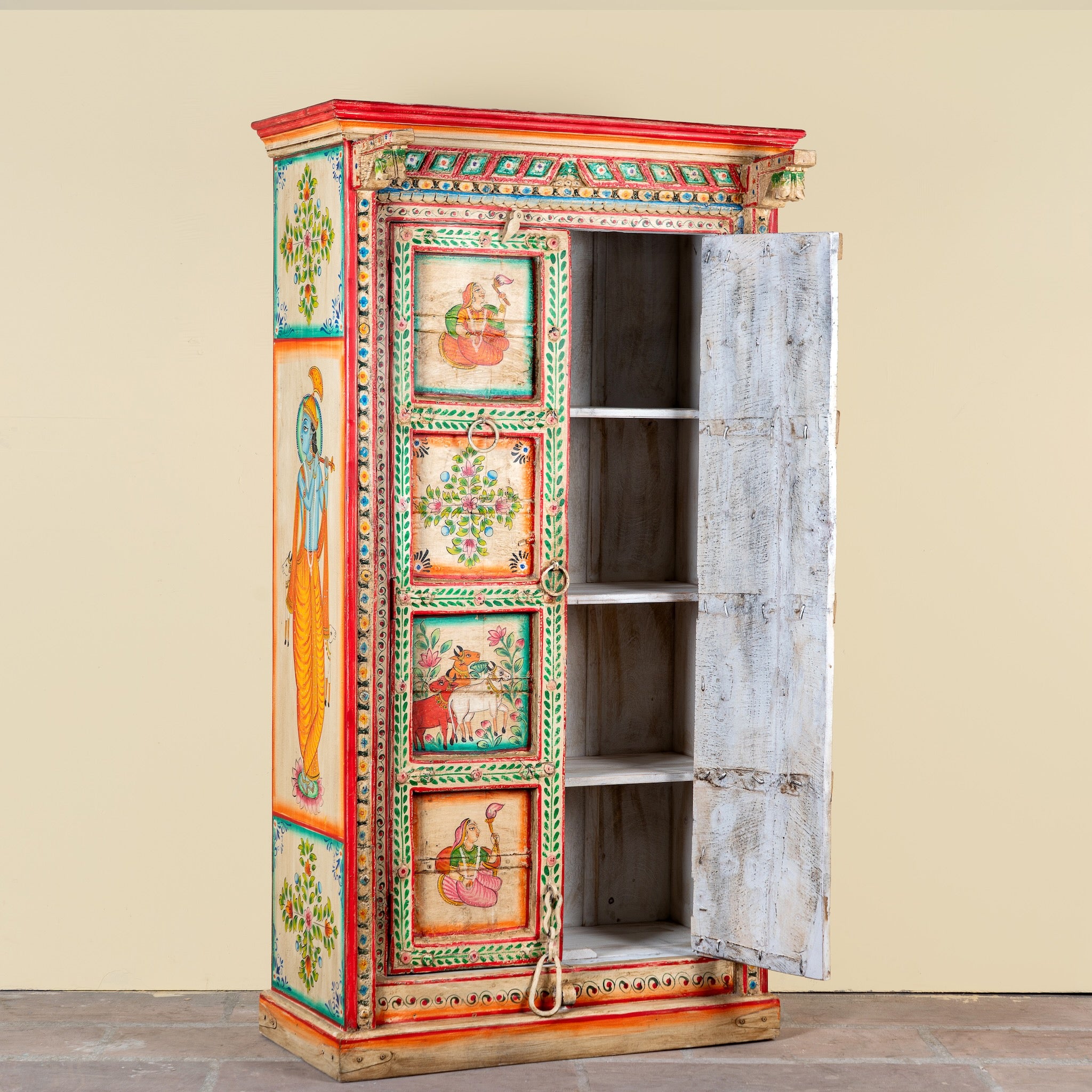 Side angle image with open door of a antique hand painted wardrobe made from reclaimed teak wood with Indian motifs; unique furniture and teak wood furniture, 113 × 50 × 190 cm.