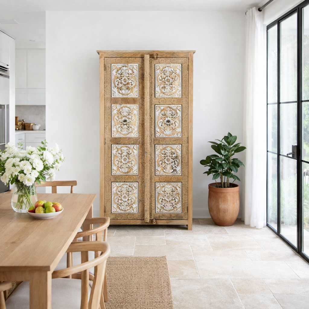 Lifestyle image of a hand carved wooden wardrobe made of solid mango wood with whitewashed floral details; Ibiza-style mango wood wardrobe, 190 × 100 × 40 cm.