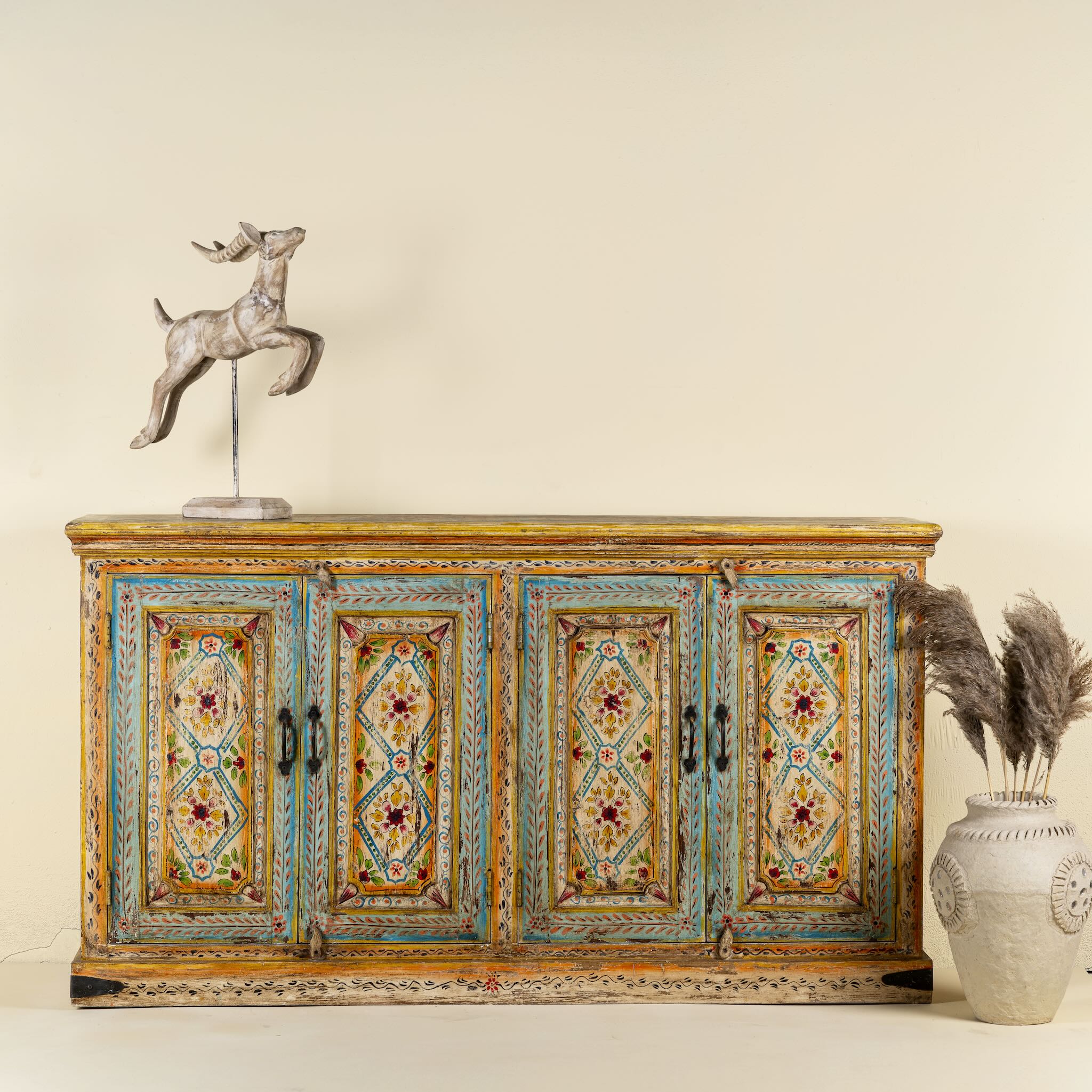 Image of a hand painted wooden dresser with floral and geometric motifs, reclaimed wood living room furniture in vintage boho style, 170 × 45 × 95 cm.