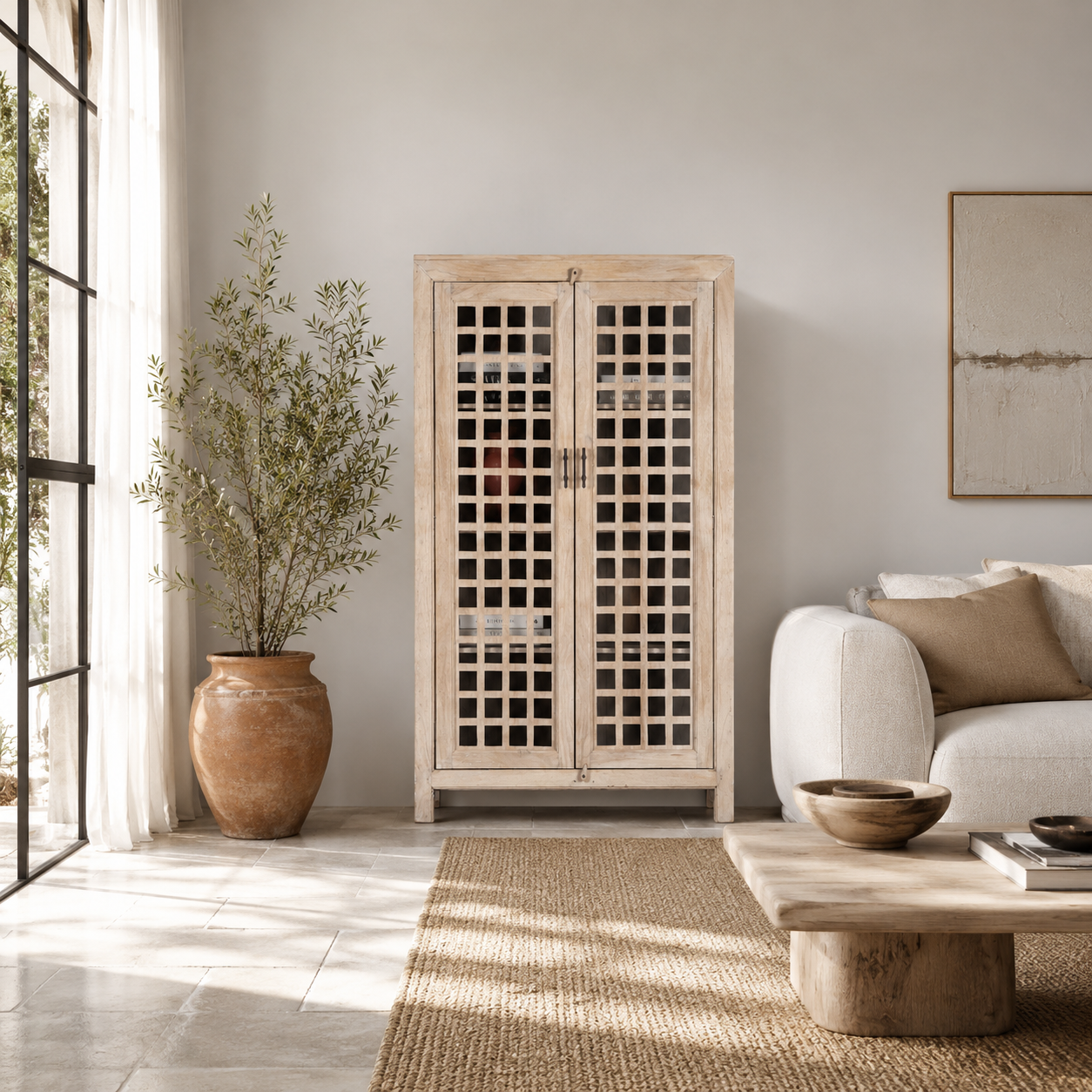 Life style image of a sandblasted mango wood showcase with two glass-panelled grid doors and four interior compartments, finished in a light sun-washed tone, ideal as living room furniture.
