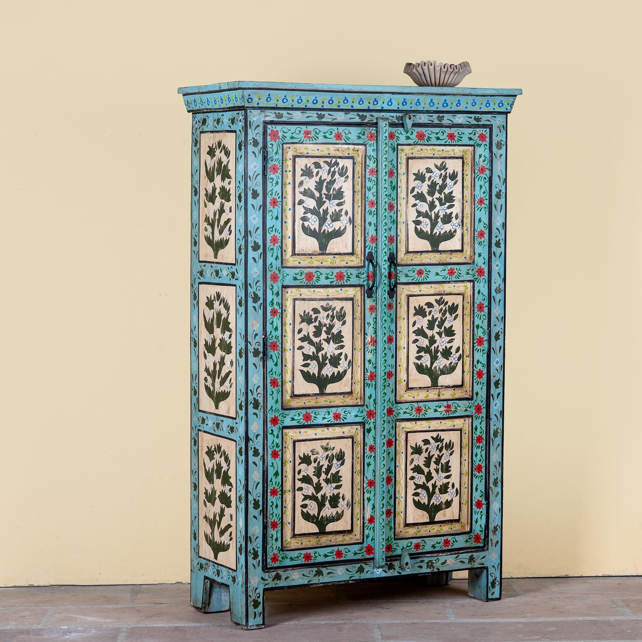 Side angle image of a Hand-painted reclaimed wood cabinet with floral motifs and green frame – Drisina by Om Home & Garden, a unique piece of sustainable furniture with bohemian flair.