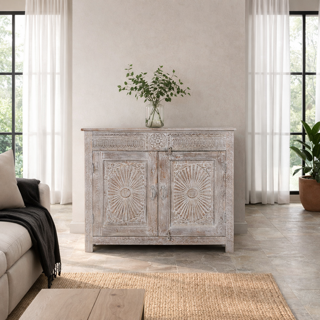 Lifestyle image of a grey-washed reclaimed wood cabinet with hand-carved floral and sunburst detailing, a vintage furniture piece perfect for rustic or bohemian interiors.