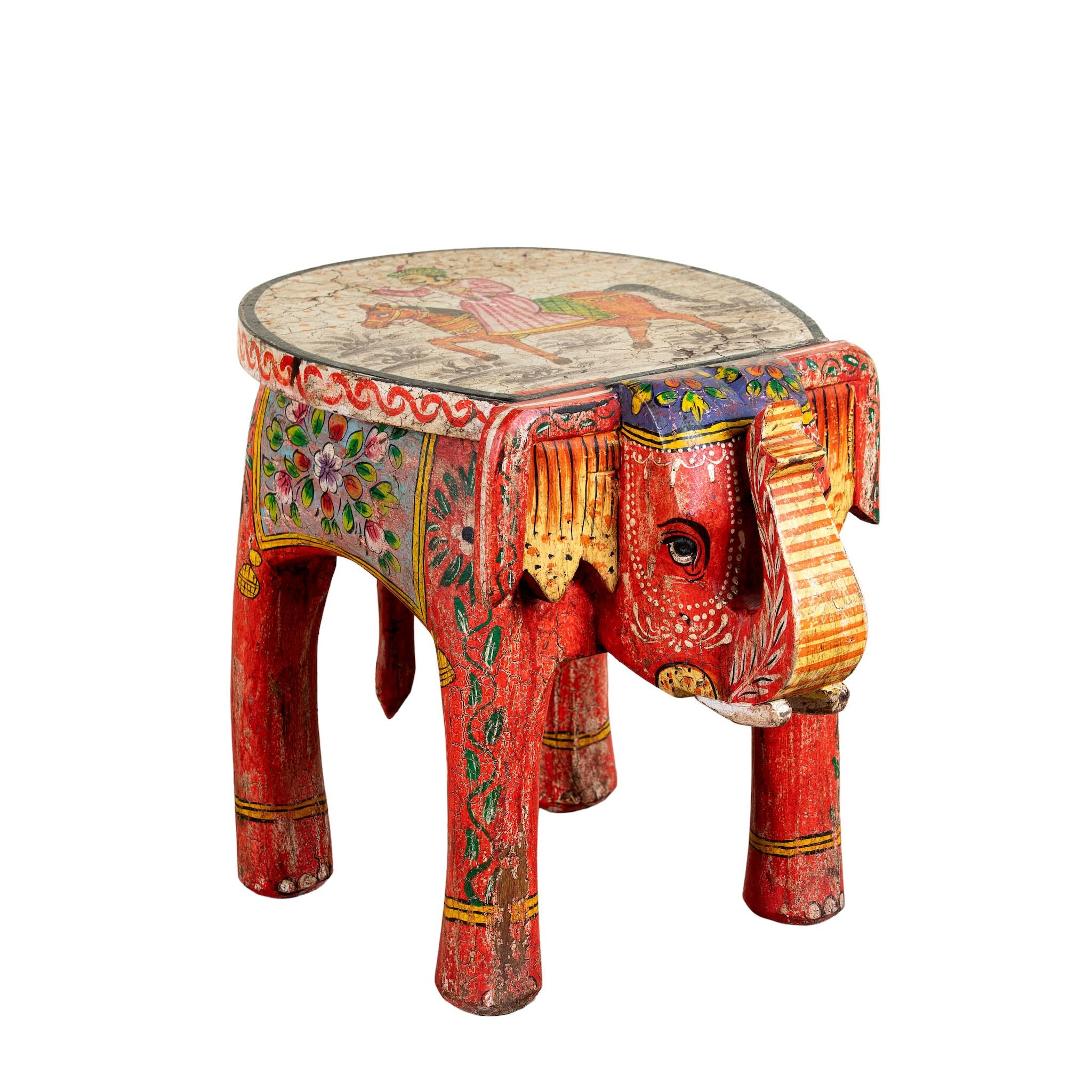 White background image of a red hand-painted wooden elephant-shaped side table with Indian folk art motifs and floral details, perfect for vintage or global home decor.