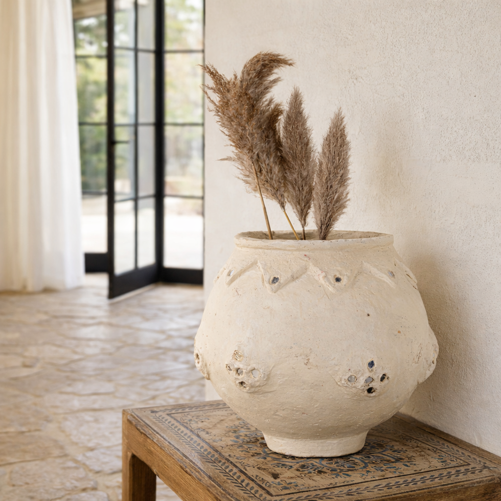 Lifestyle image of a handmade papier-mâché vase Rasgulla with rounded shape, zigzag embossing, and mirrored inlays. A vintage home accessory and unique Indian decoration ideal for dried flowers or as a sculptural element in vintage home decor.
