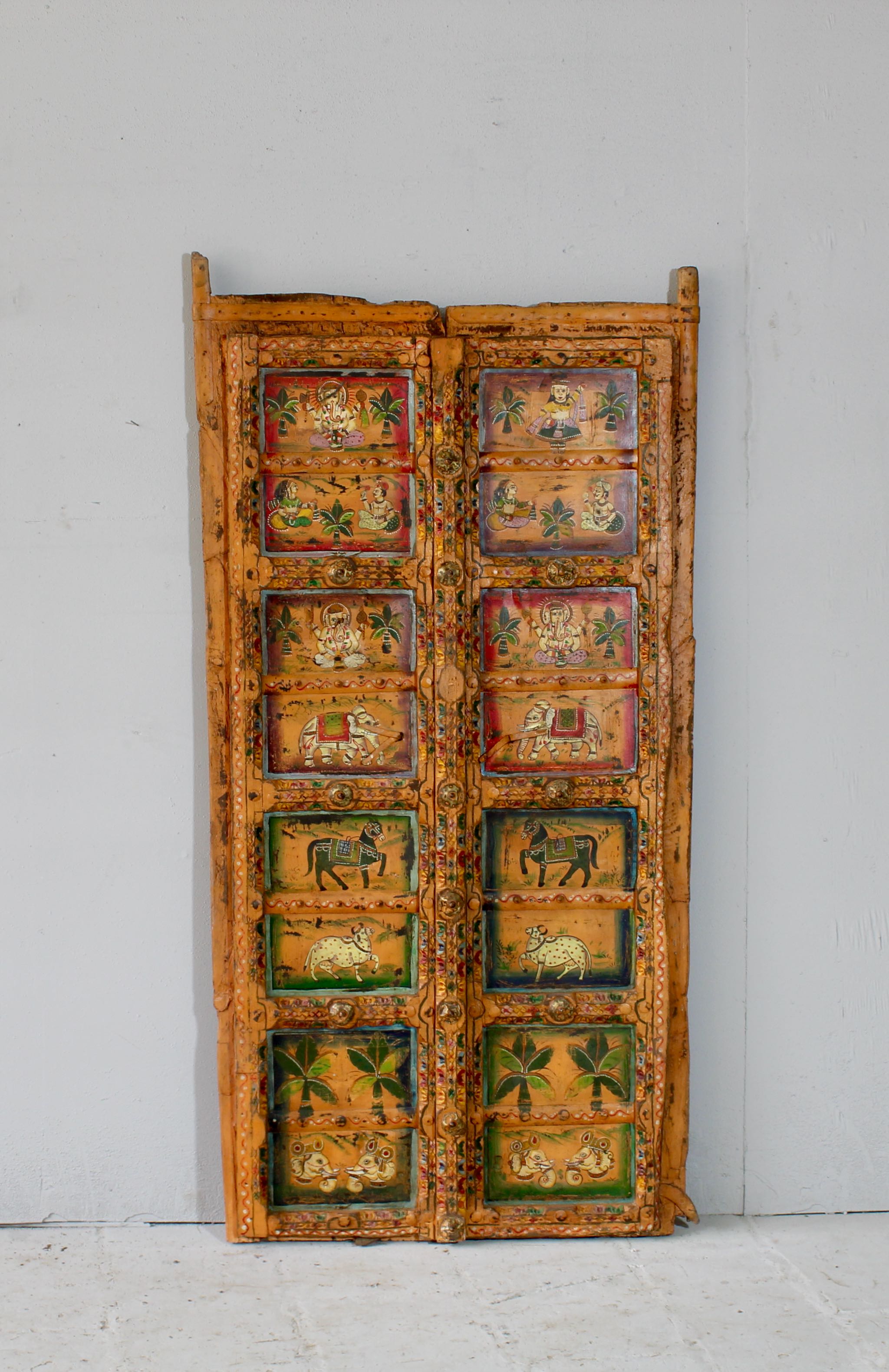 Indian painted door decoration featuring mythological and village scenes on reclaimed teak—an artisanal Indian door panel with folk motifs and vintage patina.