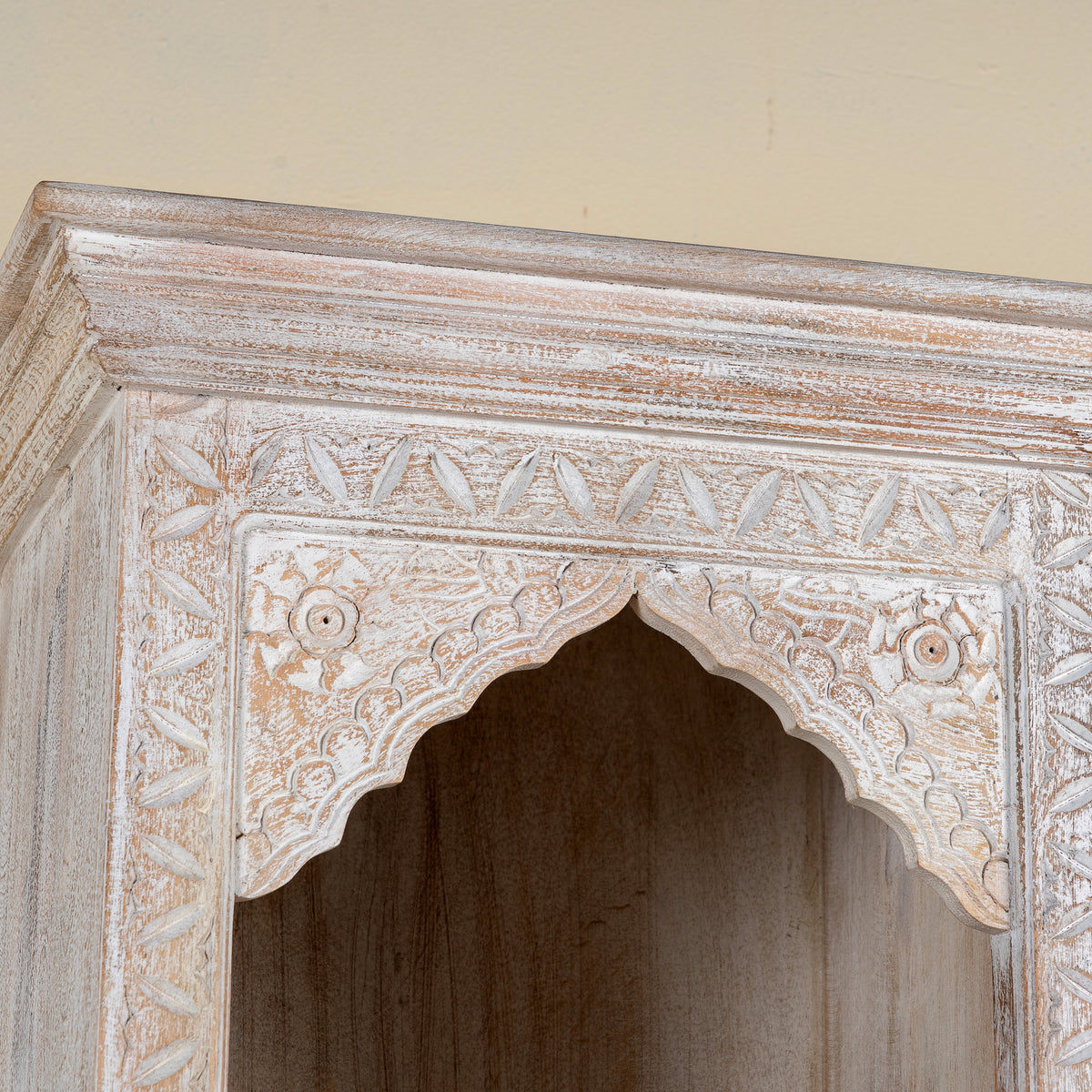 Close up image of a hand-carved mango wood bookshelf with oriental detailing and natural wood finish – carved wooden furniture and vertical shelving for refined, rustic interiors.