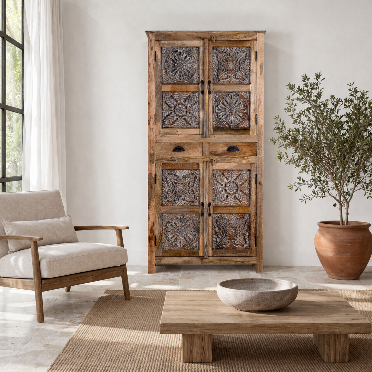 Lifestyle image of a hand-carved mango wood cabinet with floral motifs and silver finish – bedroom furniture with rustic charm and artisanal detail.