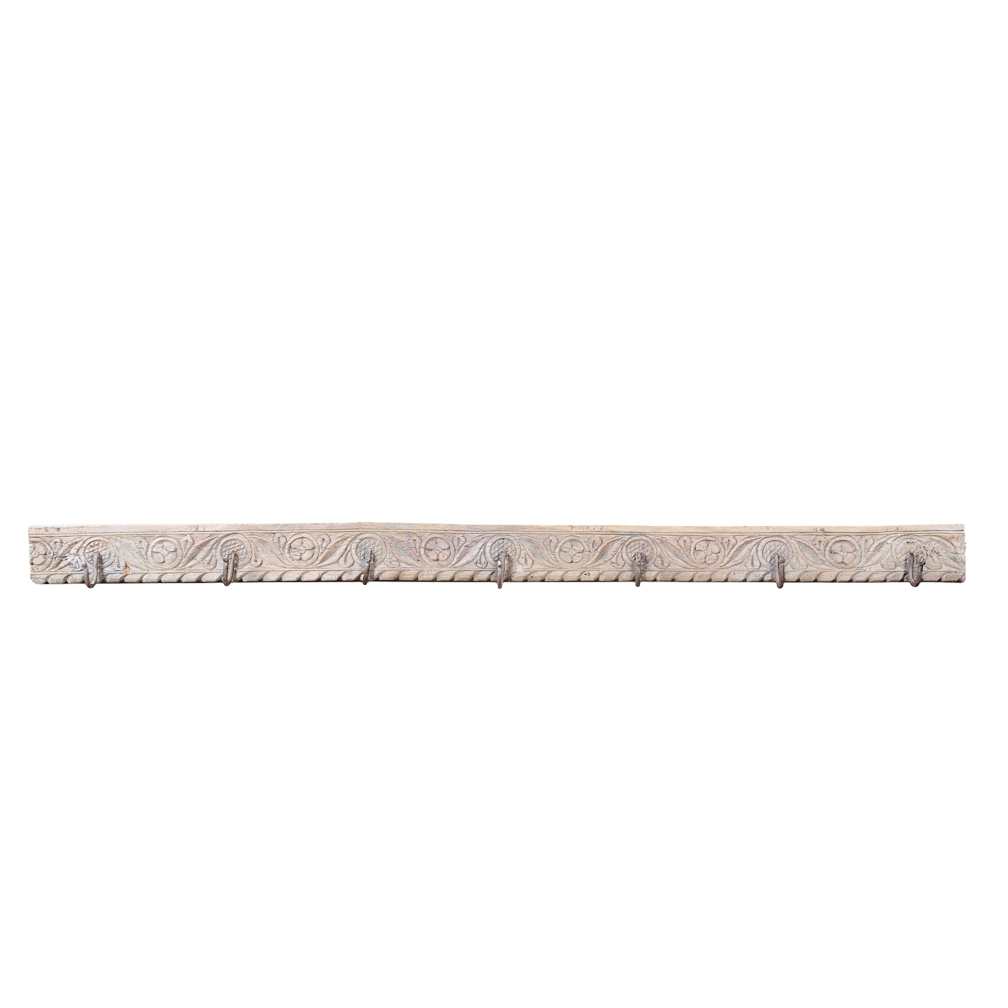 White background image of a Jaipur Wall Hook Rack handcrafted from an antique Indian reclaimed wood architectural element with hand-carved floral details, bleached finish and seven iron hooks, 150x7x5cm.