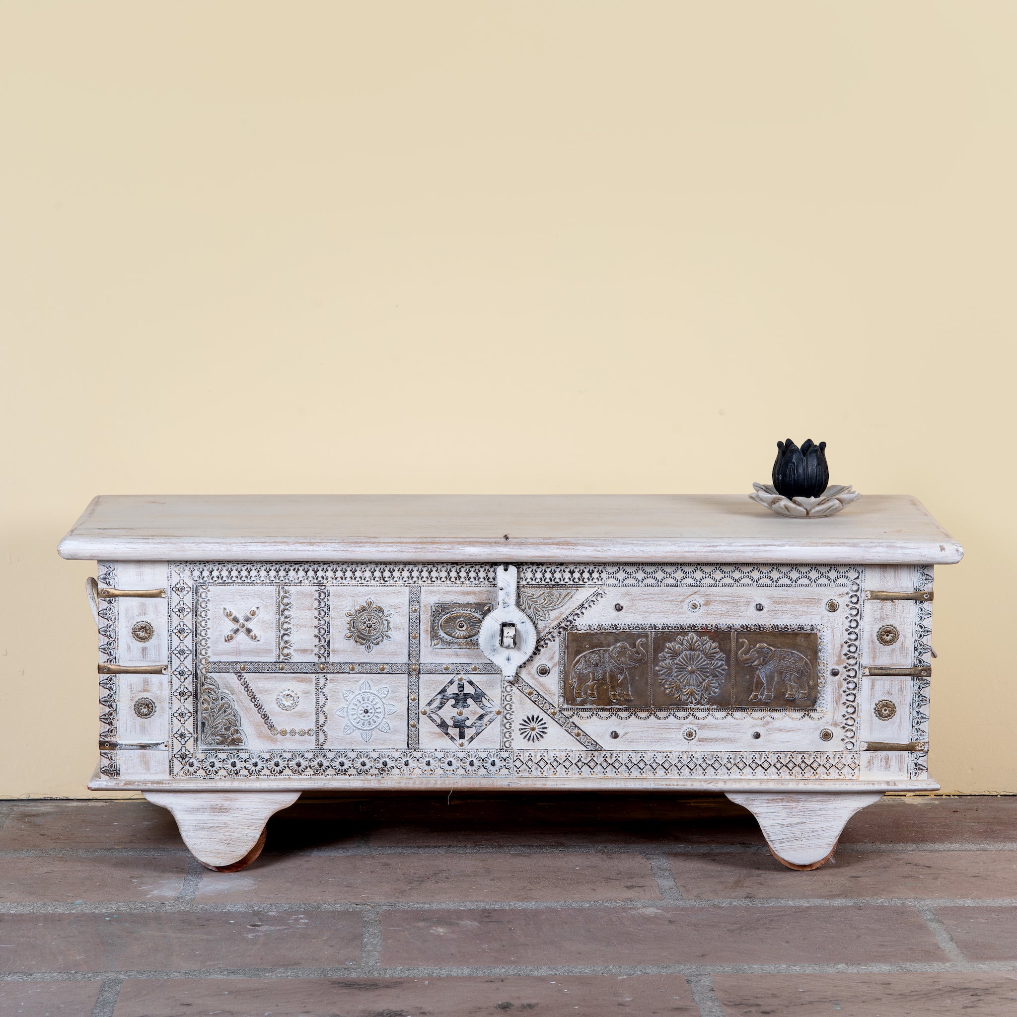Janash whitewashed mango wood coffee table chest with decorative iron fittings and wooden wheels 116cm