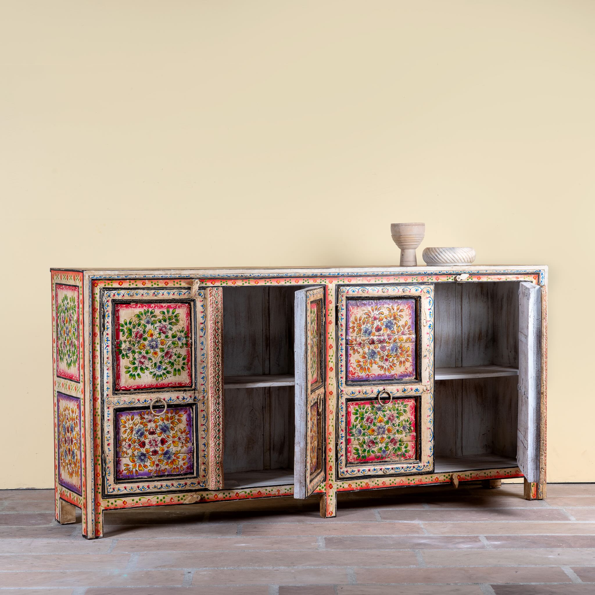 Image with open doors of a boho style hand painted sideboard with reclaimed old Indian door decoration. Unique cabinet with floral design.