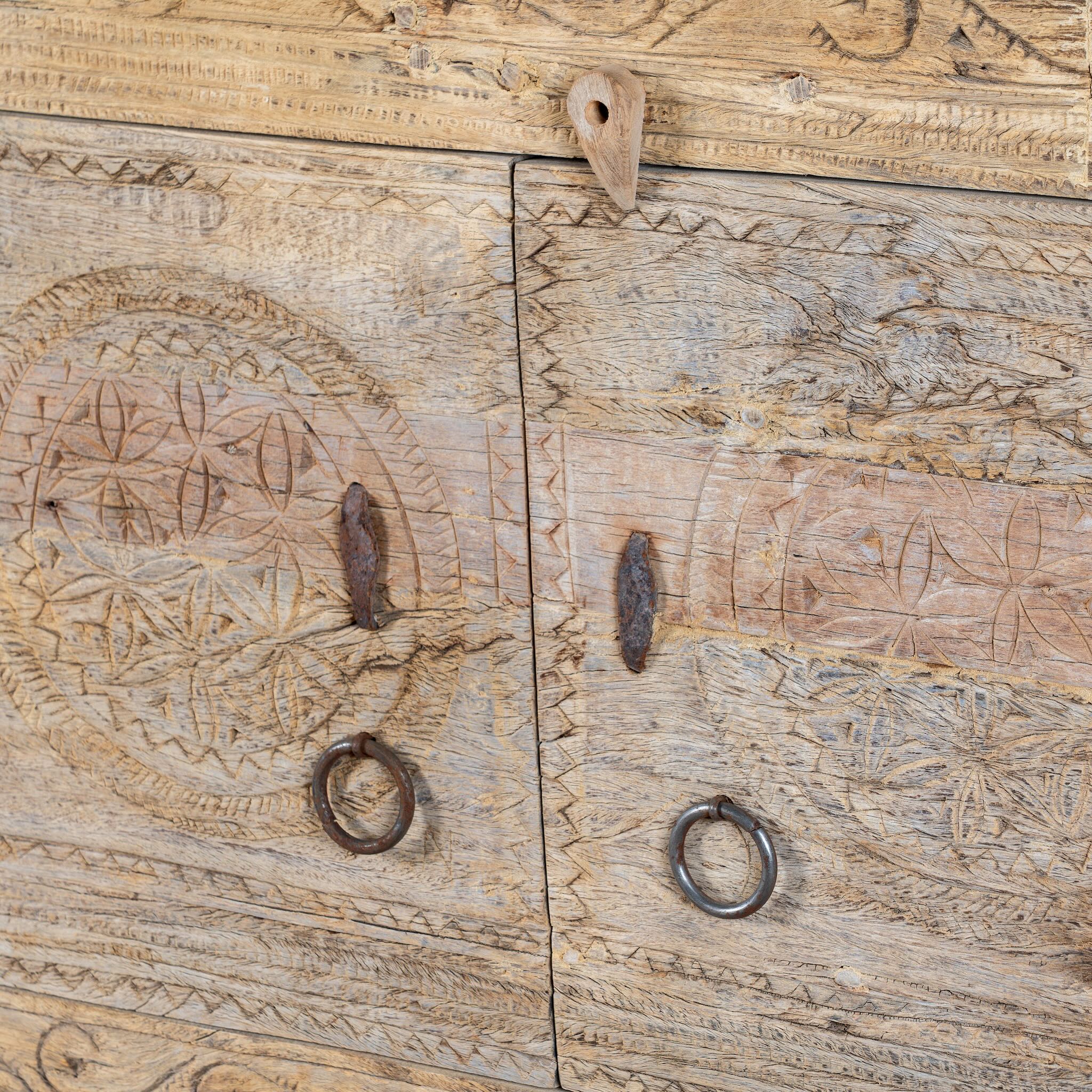 Close up image of a reclaimed wood sideboard made from antique teak doors with carved detailing; teak furniture, 110 × 45 × 83 cm.