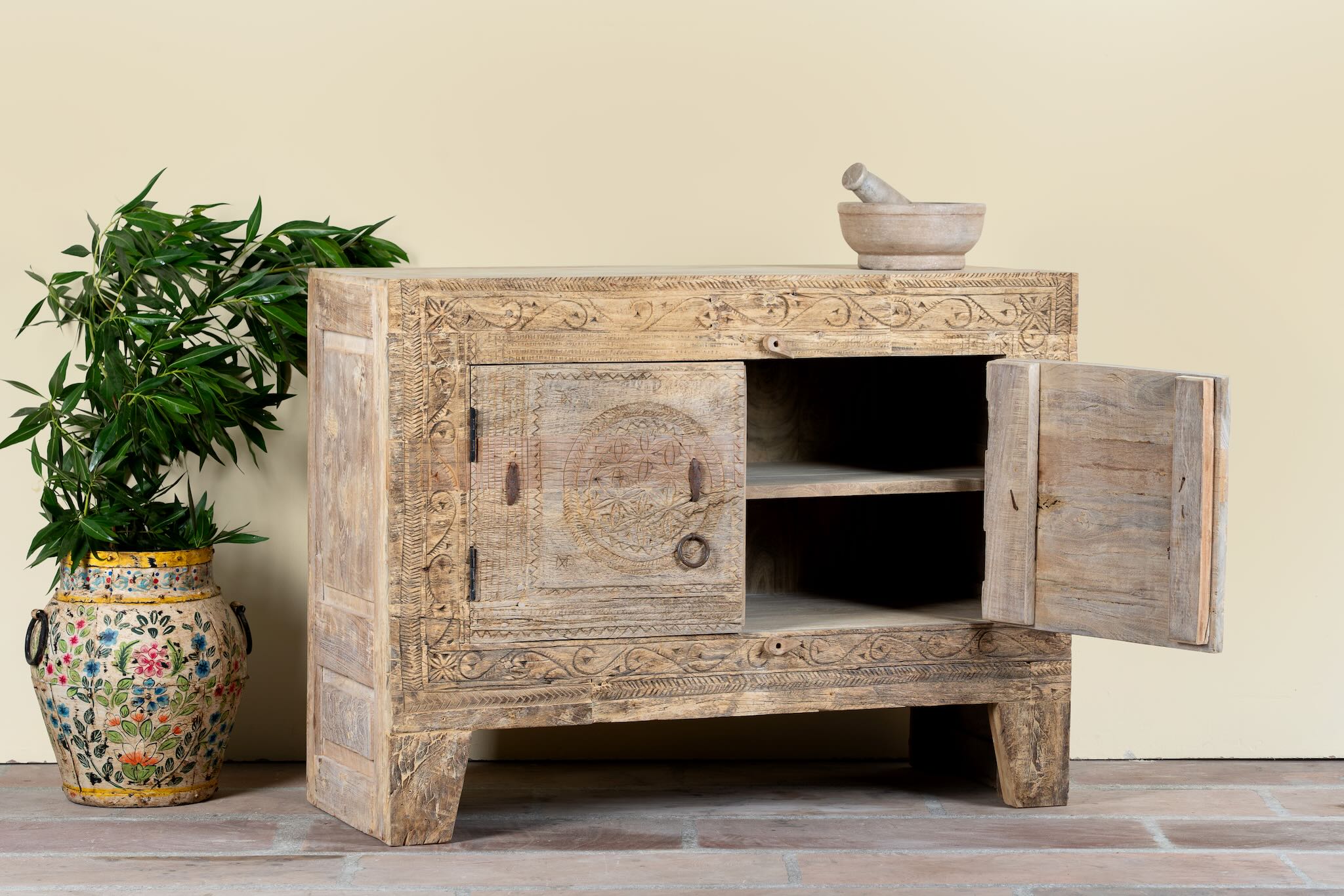 Side angle image with open door of a reclaimed wood sideboard made from antique teak doors with carved detailing; teak furniture, 110 × 45 × 83 cm.