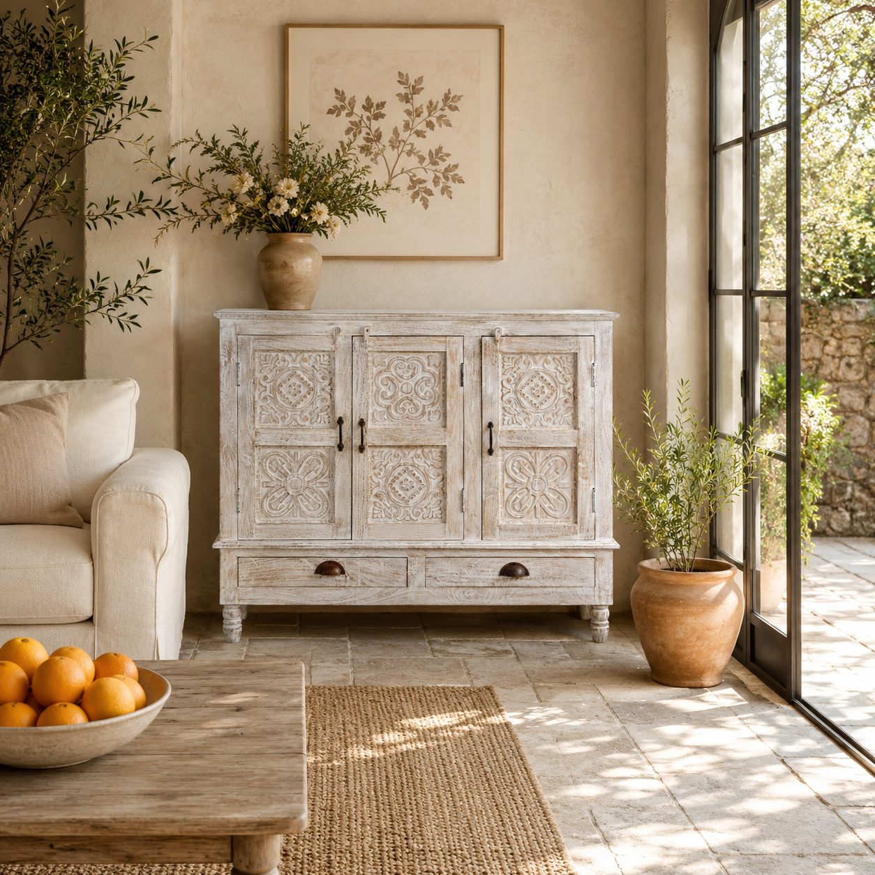 Lifestyle image of a whitewashed hand carved wooden sideboard made from solid mango wood with floral patterns, 3 doors and 2 drawers; artisanal mango wood furniture, 120 × 100 × 40 cm.