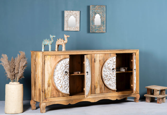 Side angle image with open doors of a carved wood furniture sideboard with whitewashed floral design, mango wood cabinet for boho chic living room, 180 × 40 × 90 cm.