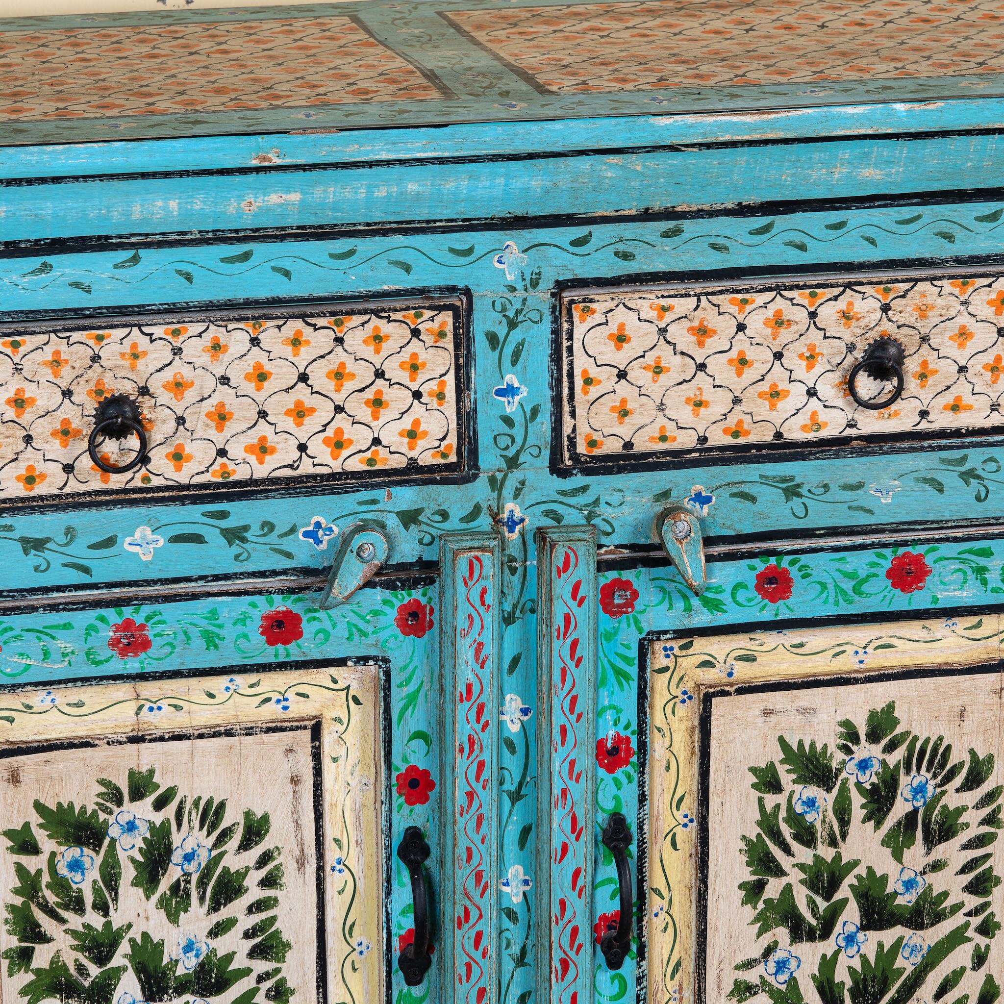 Close up image of a Kaveh hand painted reclaimed wood sideboard in boho style with three doors, three drawers, floral details, and distressed turquoise finish.