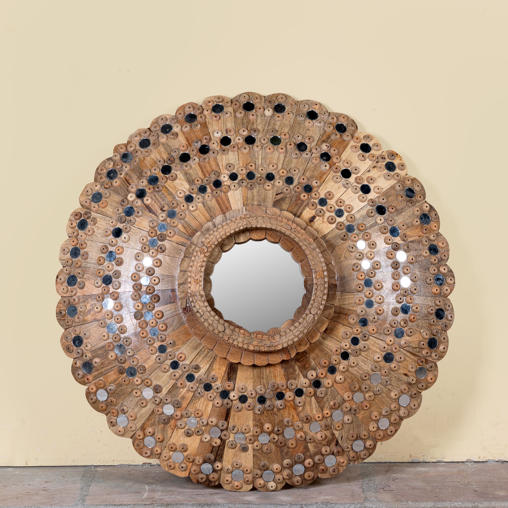 Round mango wood mirror Kiaan with concentric carved design and mirror inlays. A piece of unique wall decor combining artisanal craftsmanship and rustic bohemian charm.