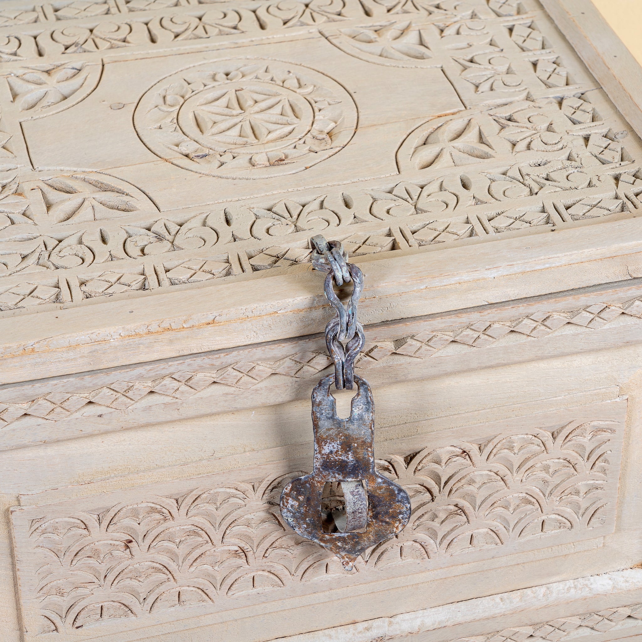 Close up image of a Kiara hand carved reclaimed wood storage box with bleached finish, antique iron lock and side carrying handles, 50x40x33cm.