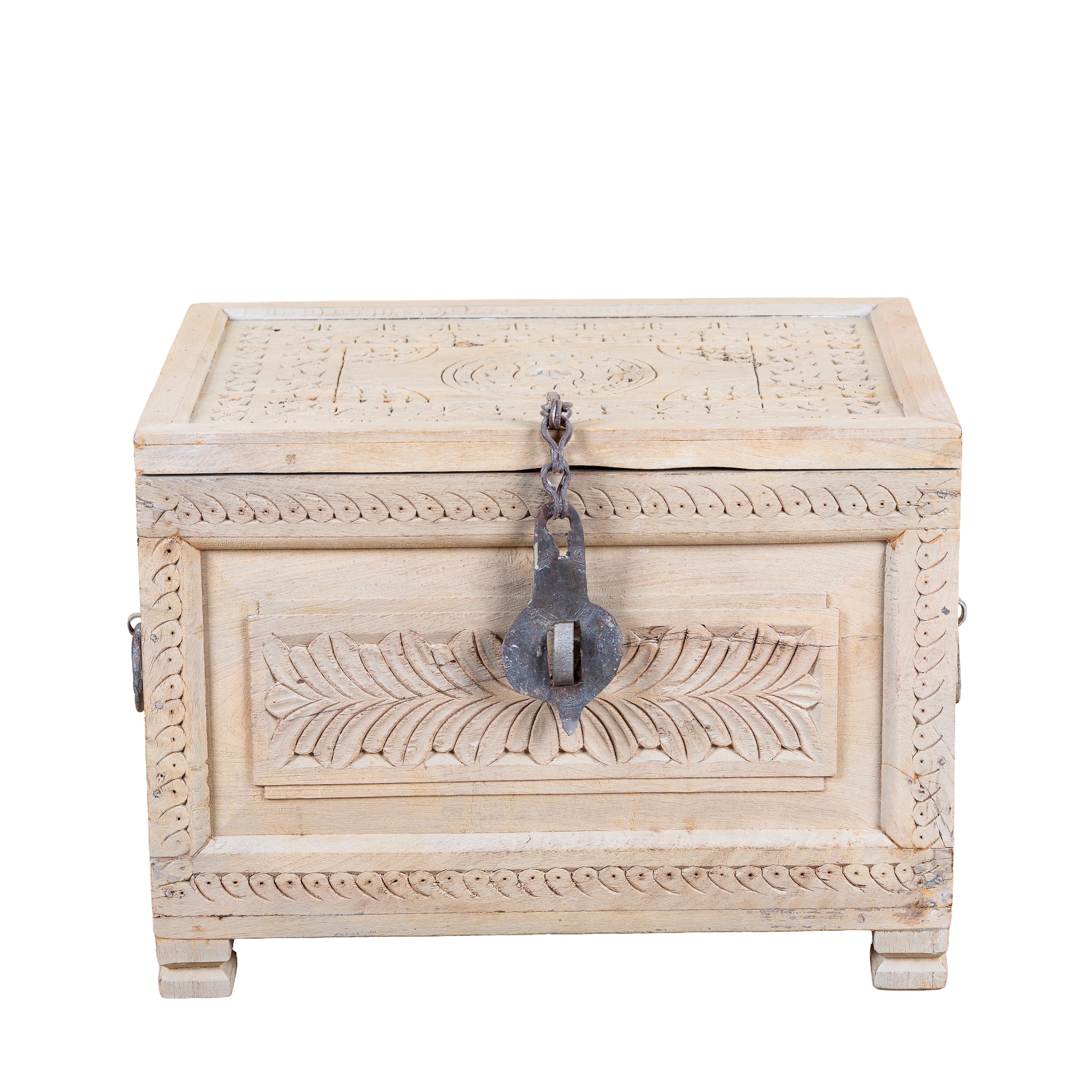 A rectangular carved wooden box in a light natural wood finish, featuring intricate floral and geometric engravings on the lid and front panel, with a dark metal padlock and chain closure on the front.