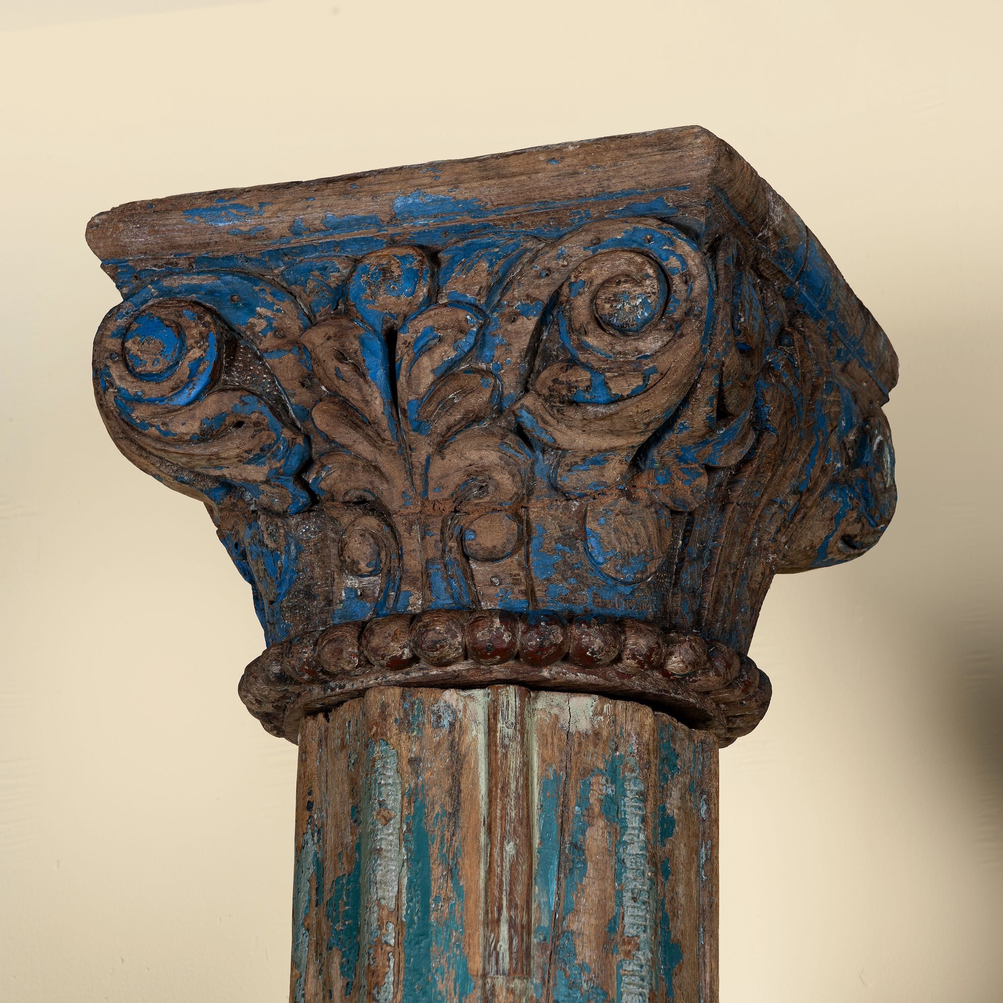 Close up image of an antique pair of carved wooden house pillars with original stone bases, weathered multicolour finish, 210 cm high, vintage home decor and boho chic living room accents.