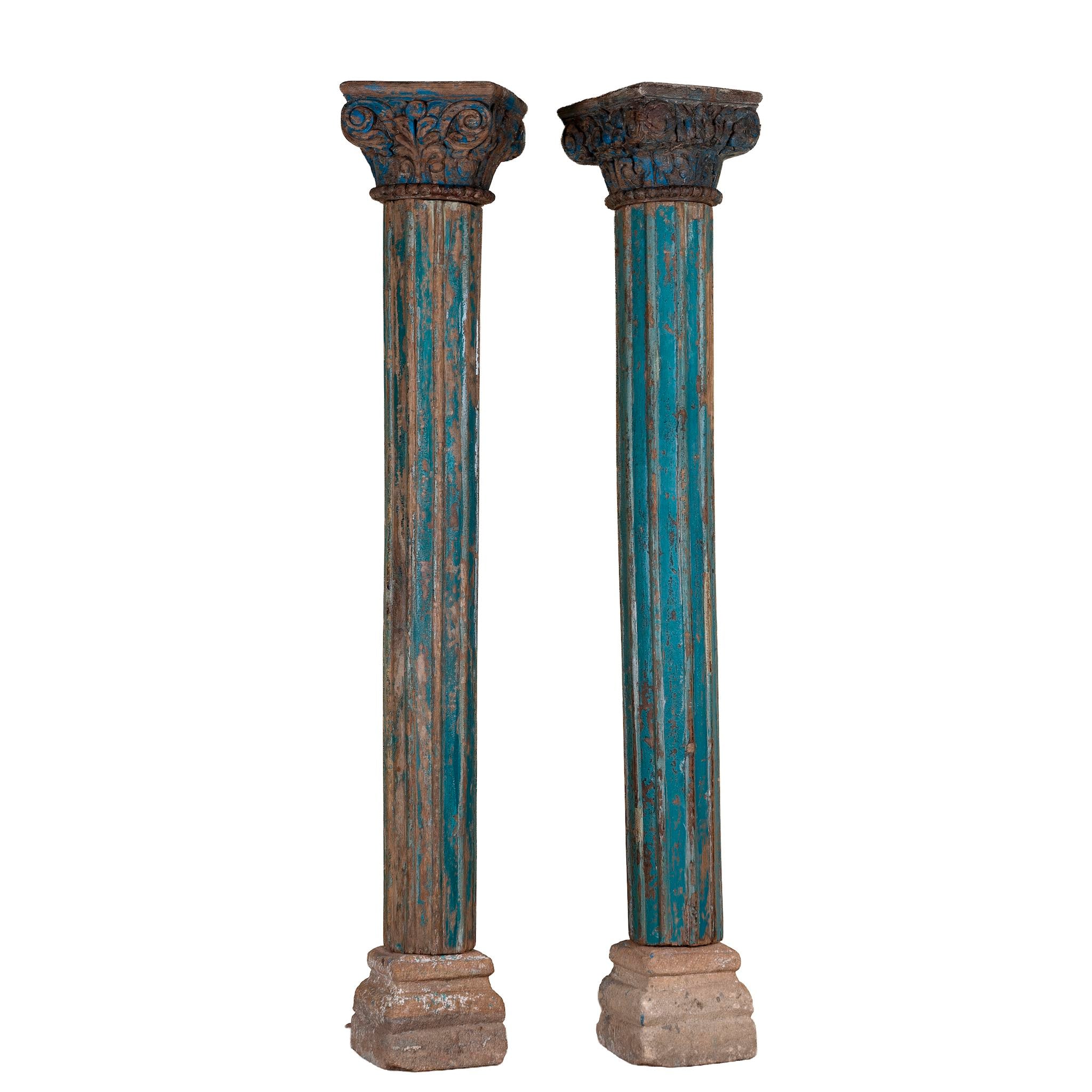 White background image of an antique pair of carved wooden house pillars with original stone bases, weathered multicolour finish, 210 cm high, vintage home decor and boho chic living room accents.
